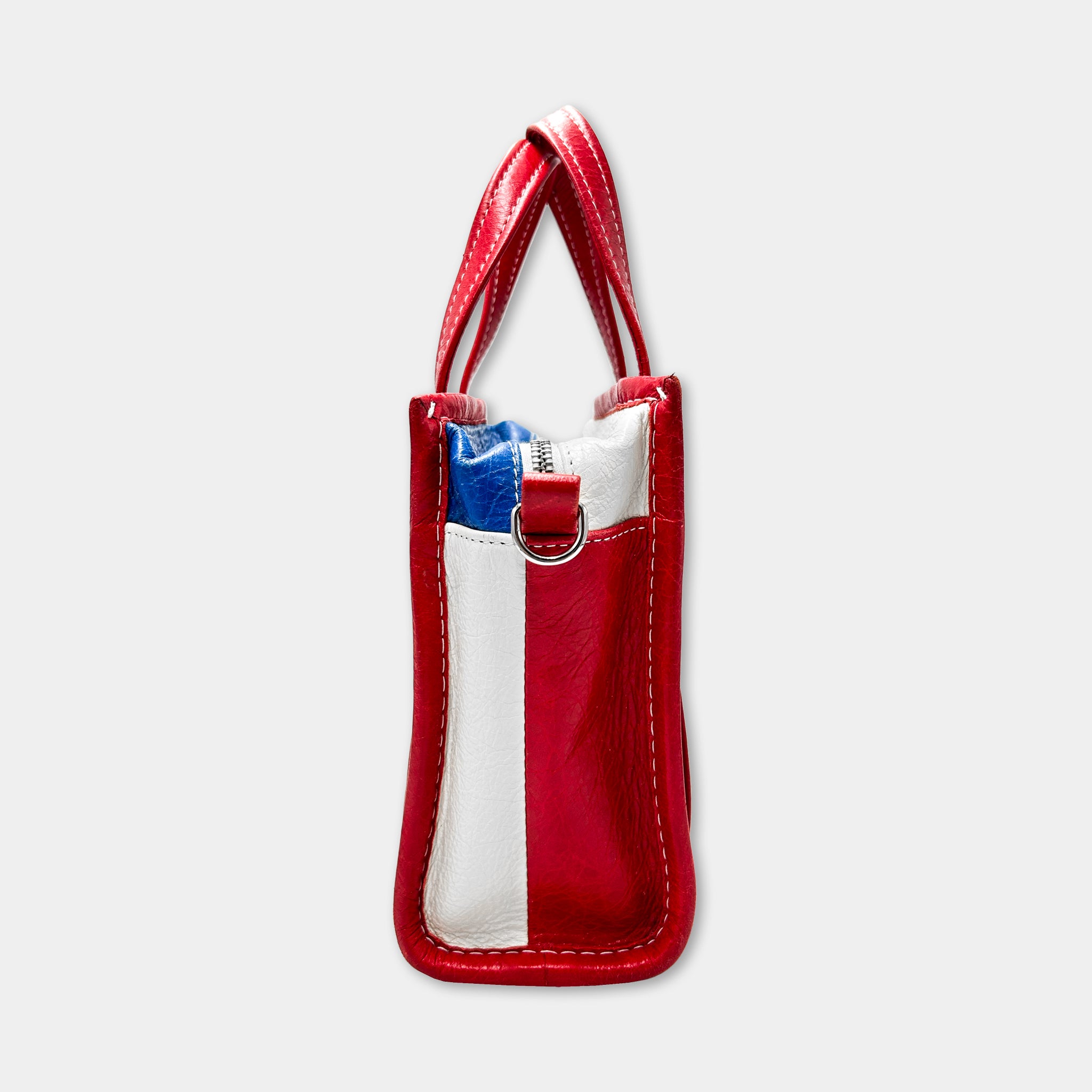 A red and white handbag with a zipper closure and two handles.