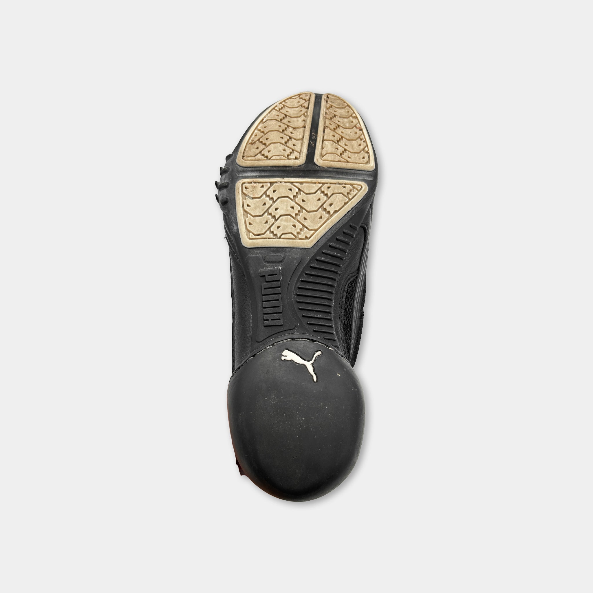 A black and tan athletic shoe with a distinctive Puma logo on the sole.