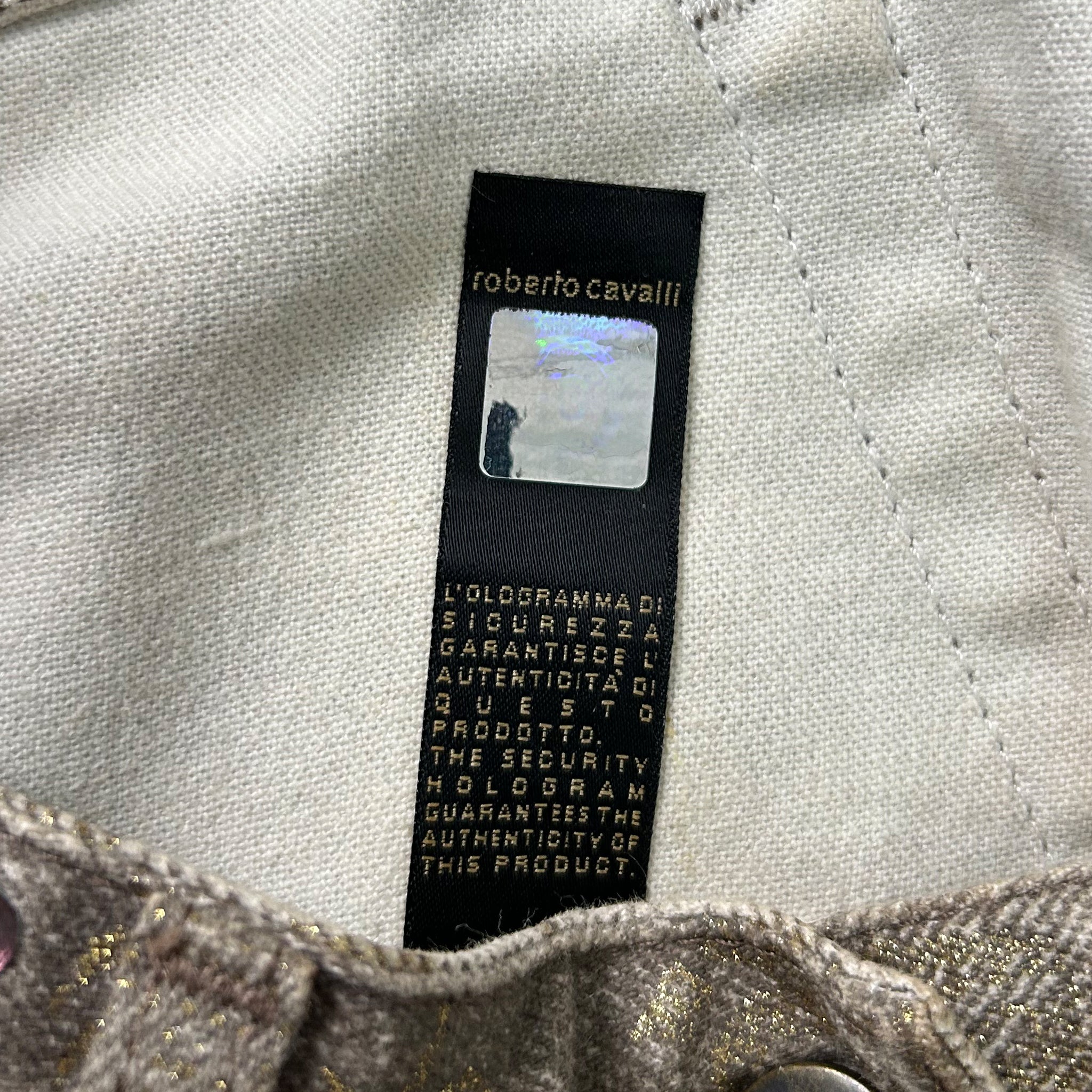 a close-up of a fabric label with text and a small image, likely a product description or information about the fabric.