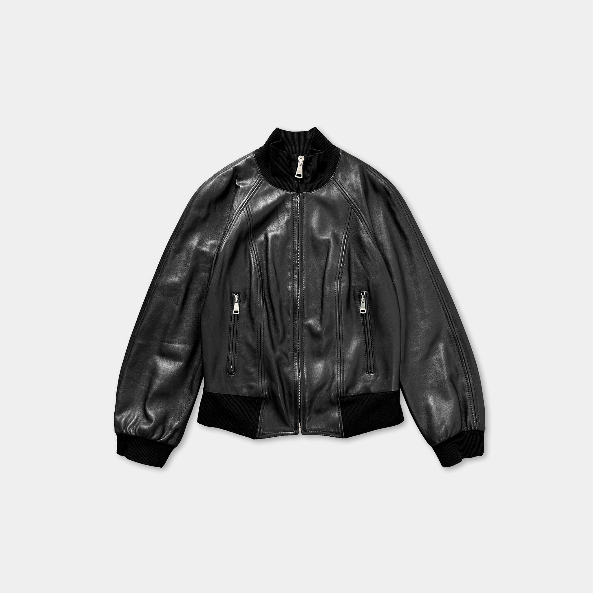 A black leather jacket with long sleeves and a high collar, featuring two zippers on the front.