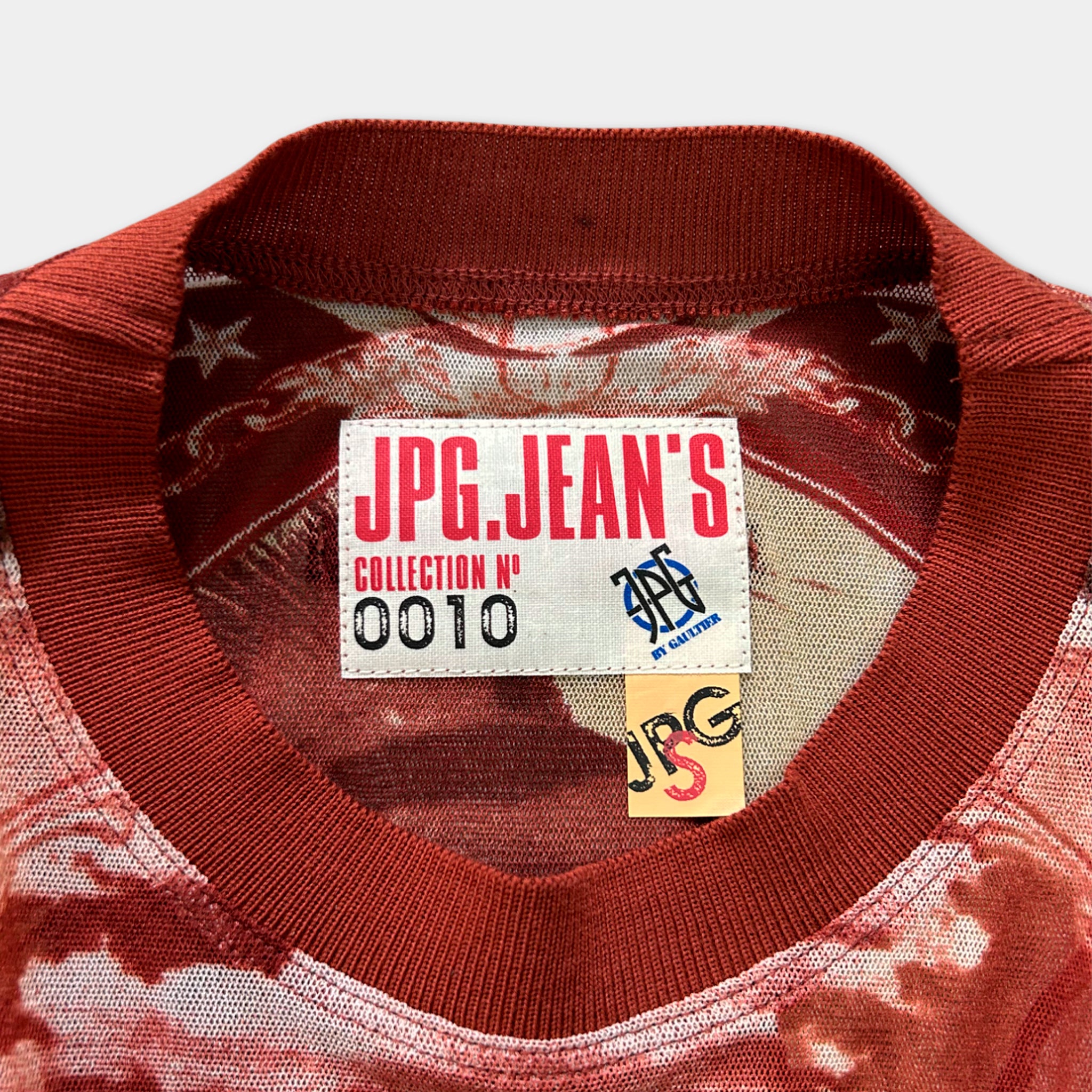 a close-up view of a red collar on a shirt, with a label attached to it.
