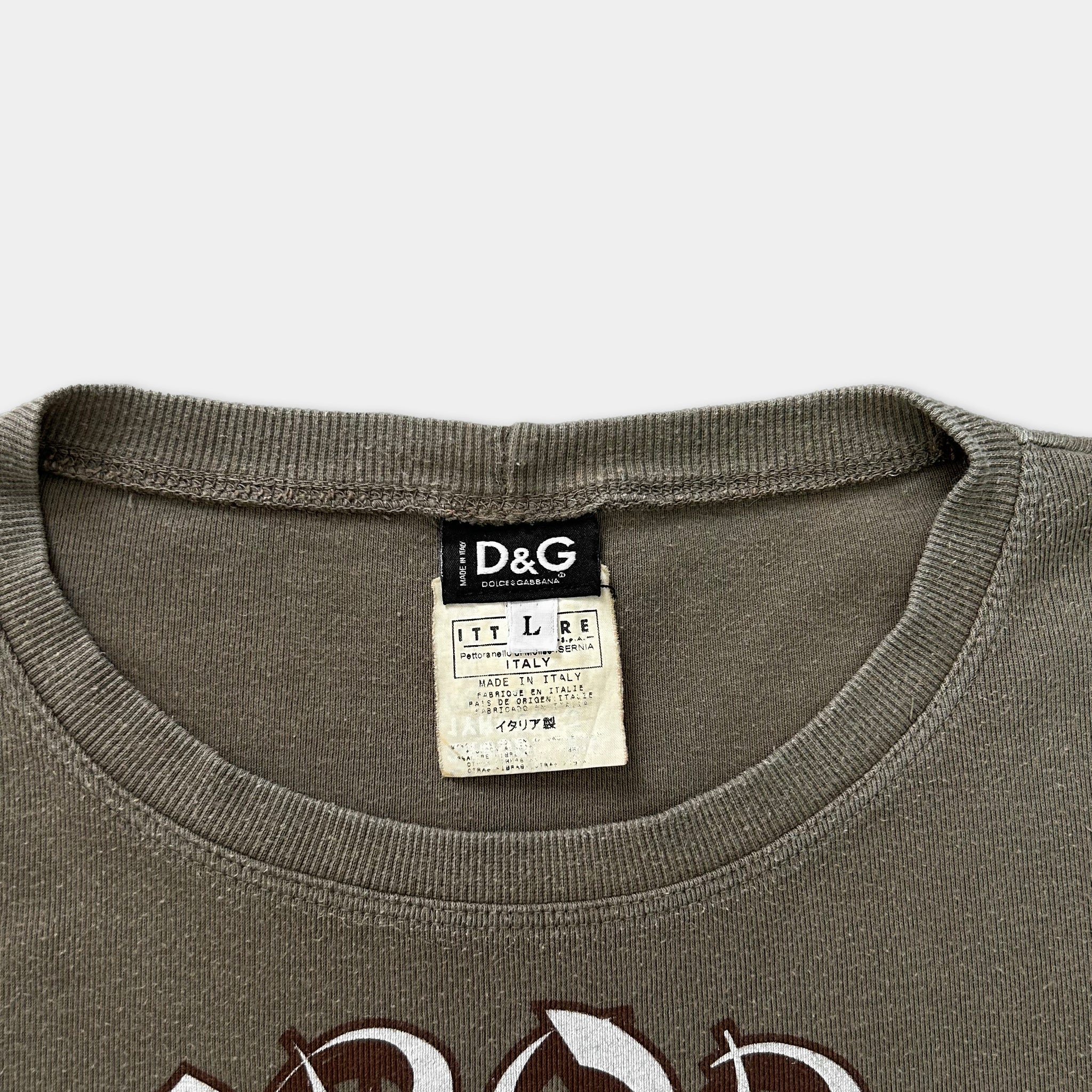 a close-up view of a gray t-shirt with a black and white label attached to the collar.