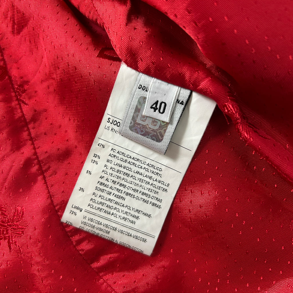 a close-up view of a red fabric with a label attached to it, which appears to be a price tag or price label.
