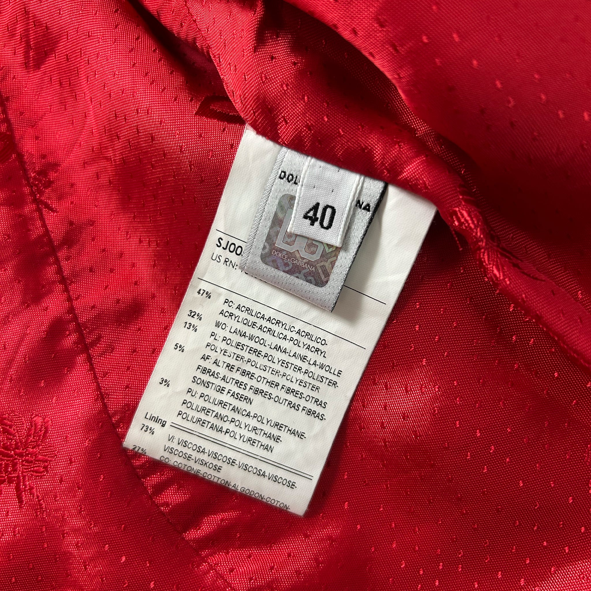 a close-up view of a red fabric with a label attached to it, which appears to be a price tag or price label.