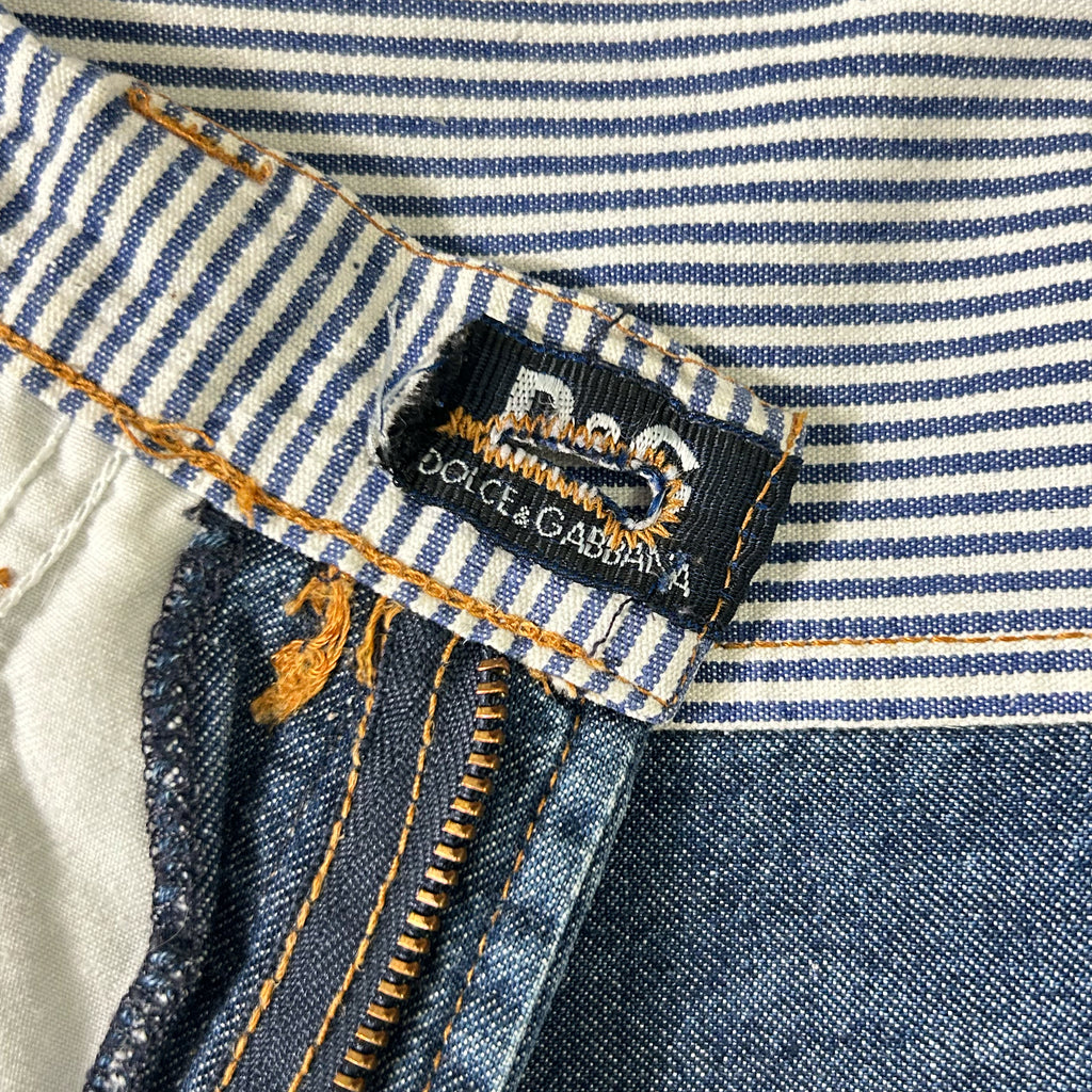a close-up view of a pair of blue and white striped jeans, with a black and white label attached to the waistband.