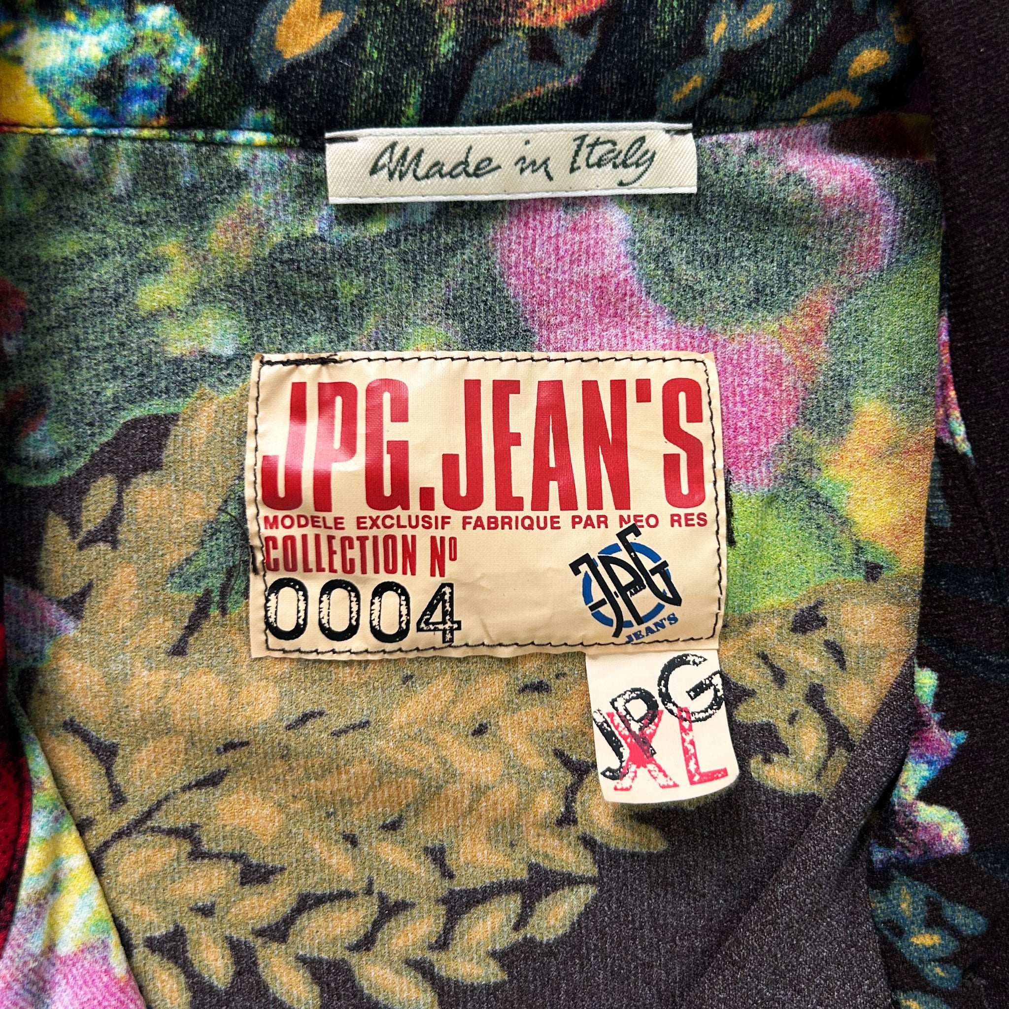 a close-up view of a colorful fabric with a label that reads "Made in Italy" and a tag that says "UPG.JEAN'S COLLECTION NO. 004".