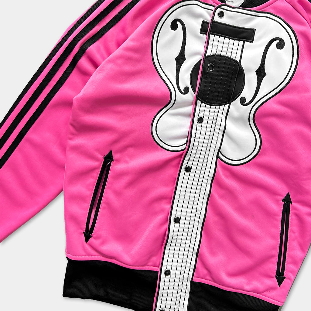 A bright pink track jacket with a black and white guitar design on the front.