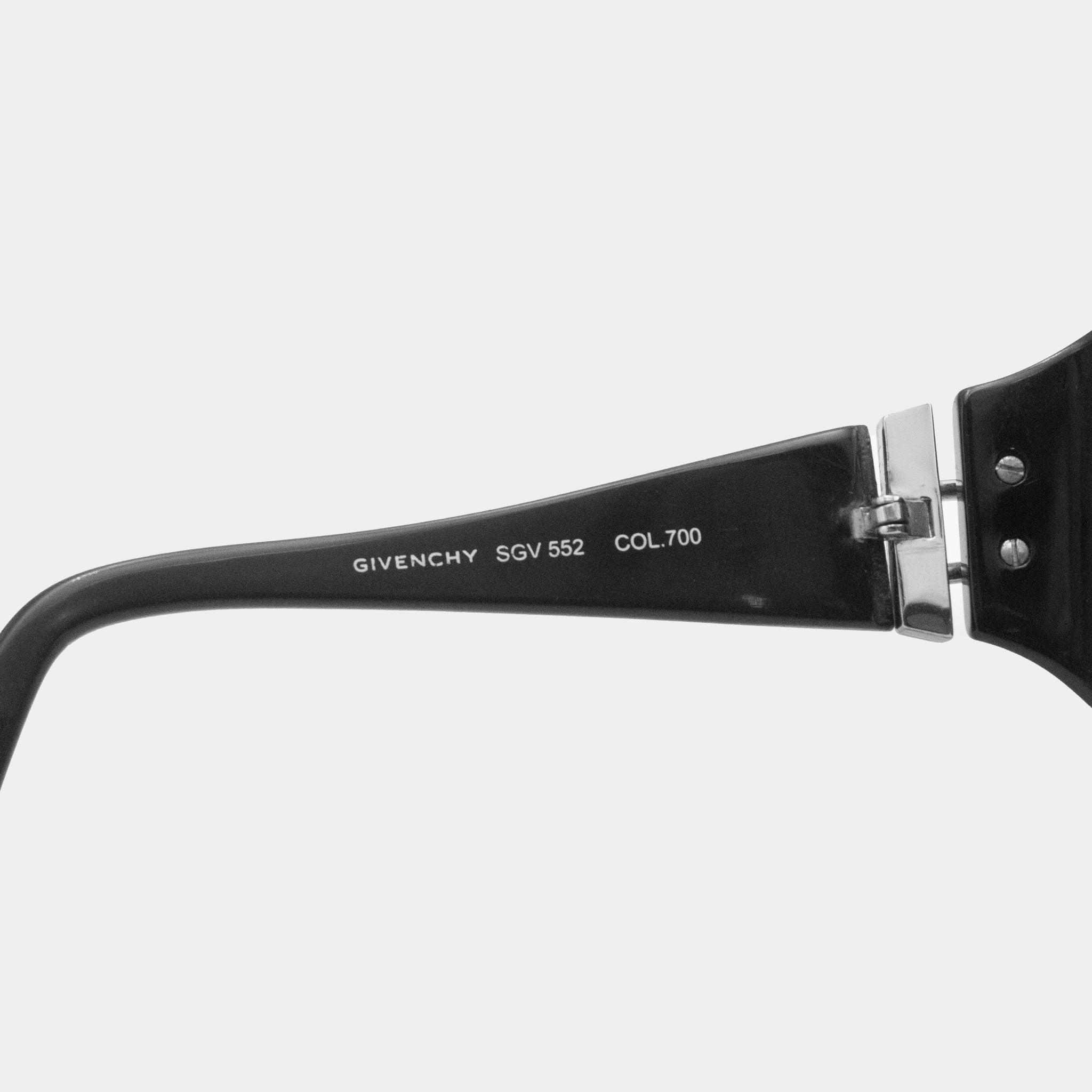 A close-up view of a pair of black-framed sunglasses with the brand name "GIVENCHY" printed on the frame.
