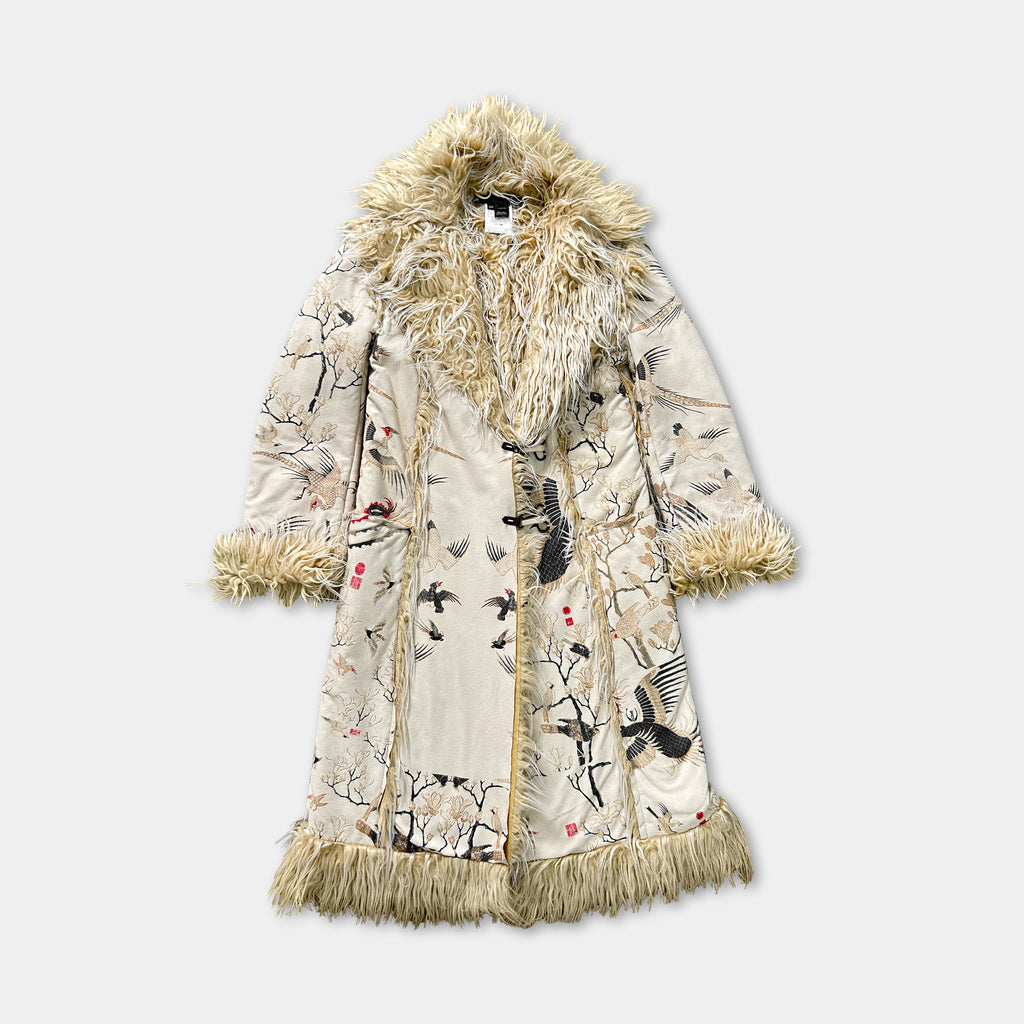 A long, beige coat with a fur collar and fringe, featuring a floral pattern and birds on the fabric.