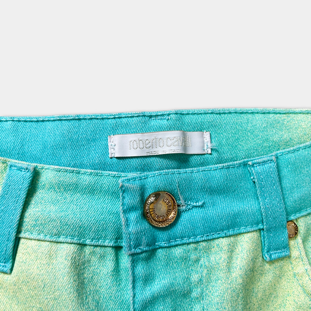 A close-up view of a pair of turquoise-colored jeans with a label on the waistband.