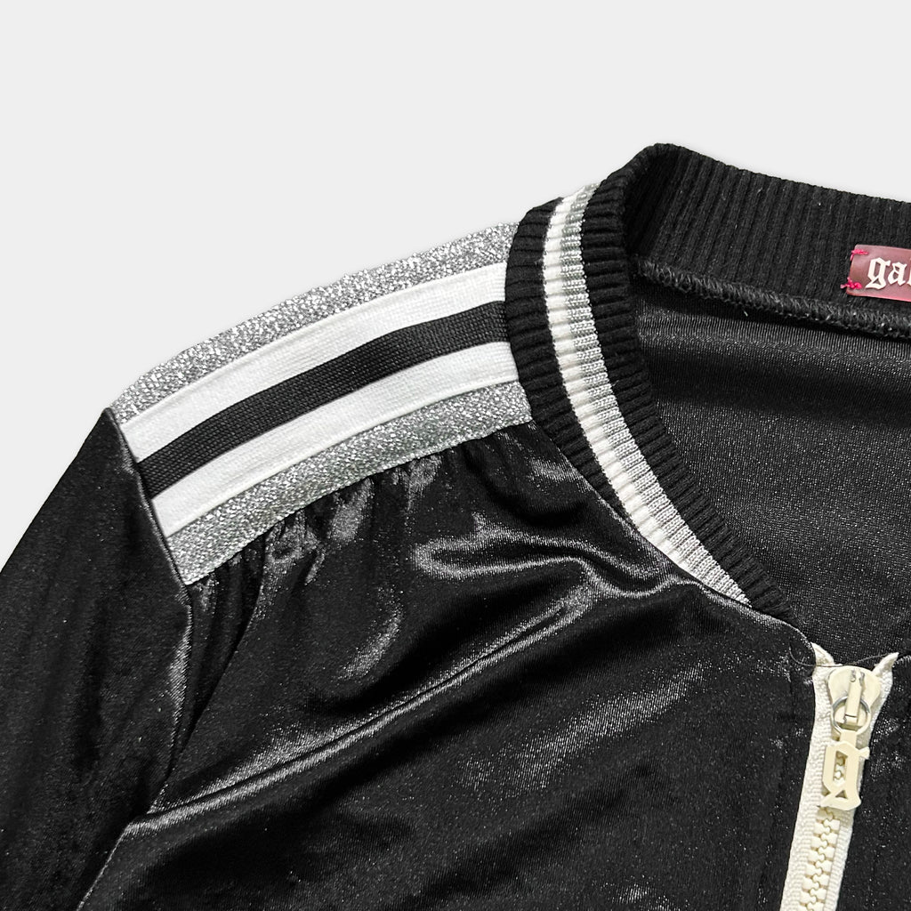 A close-up view of a black and white jacket with a zipper and a decorative trim.