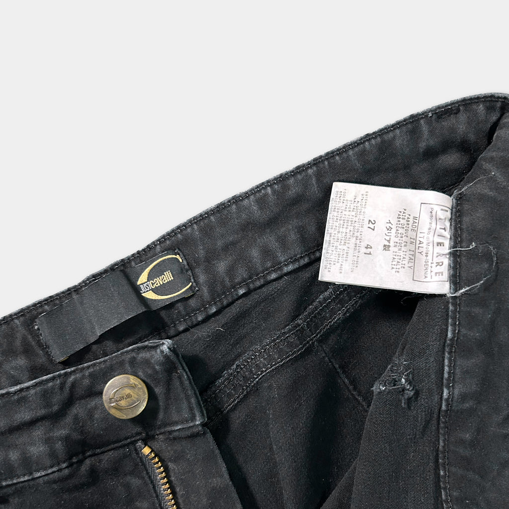 A pair of black jeans with a label attached to the waistband.