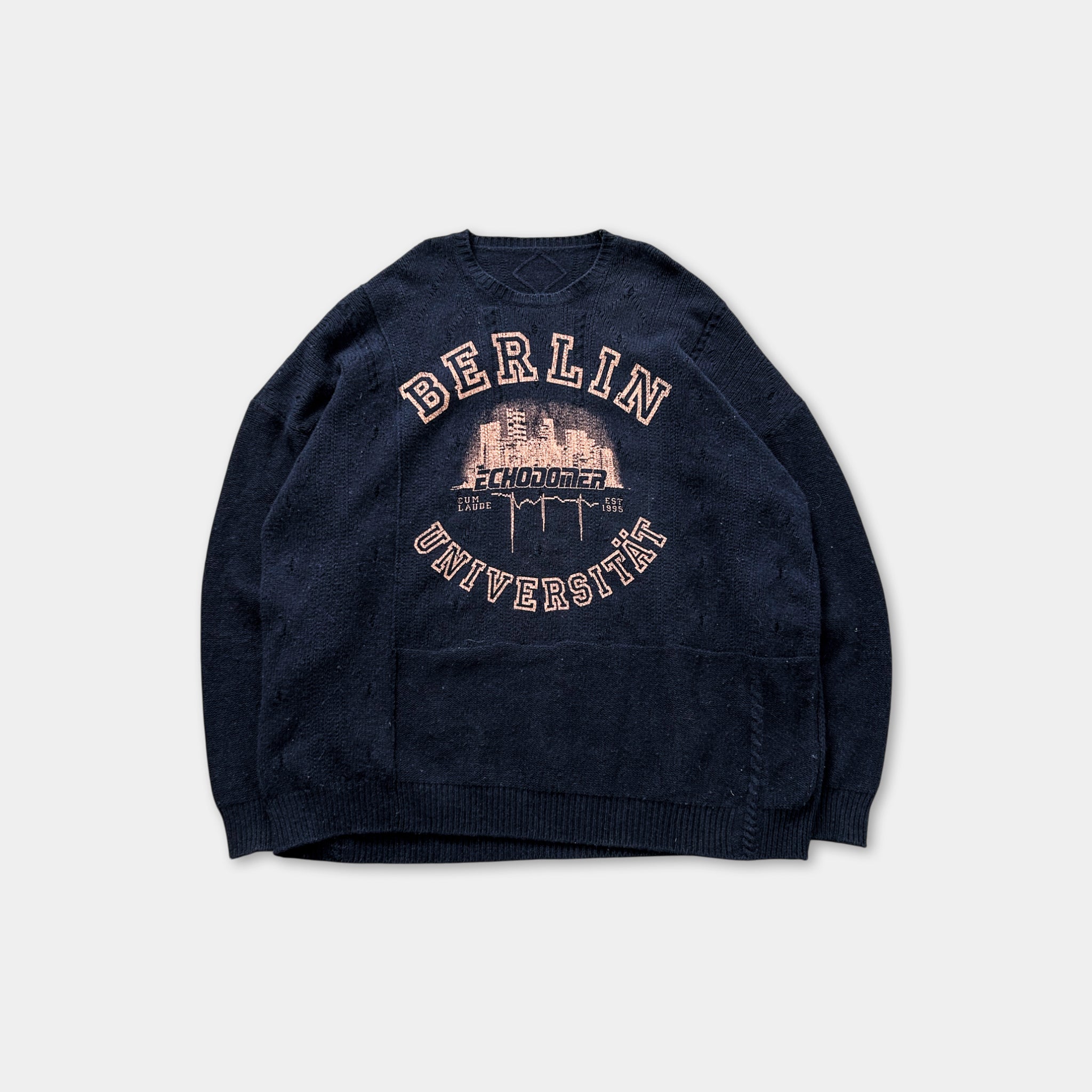 A navy blue sweater with the text "BERLIN" and "ZHUNDER UNIVERSITÄT" printed on it, along with a graphic of a city skyline.