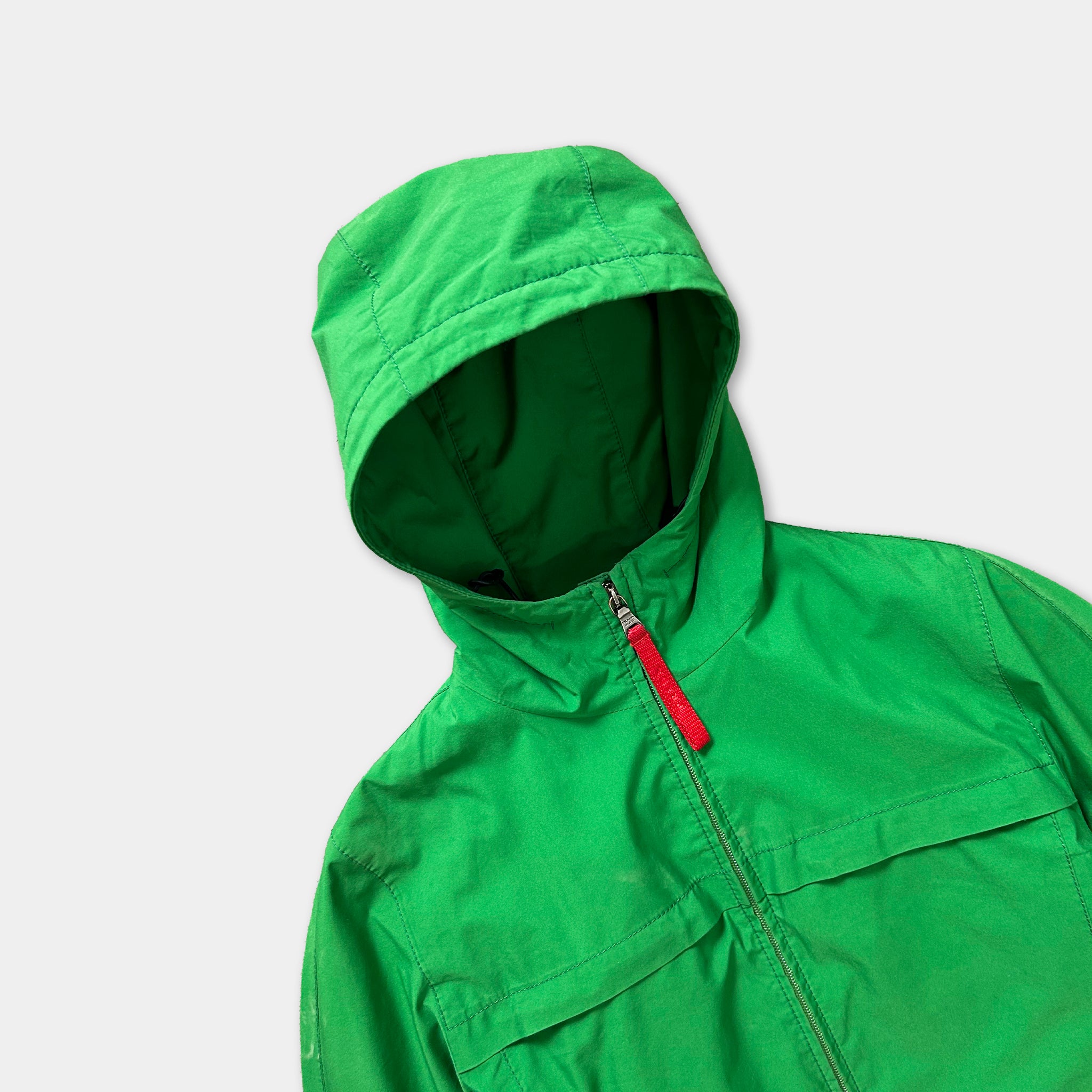 A bright green hooded jacket with a red zipper pull is shown against a plain white background.