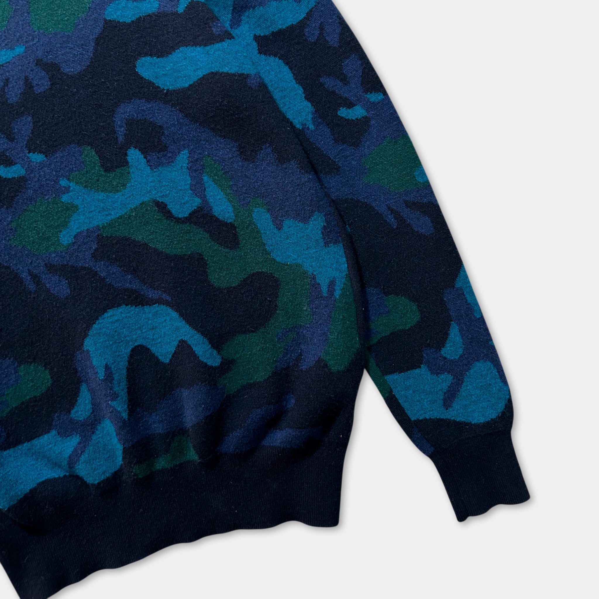 A close-up view of a blue and green camouflage patterned sweater.