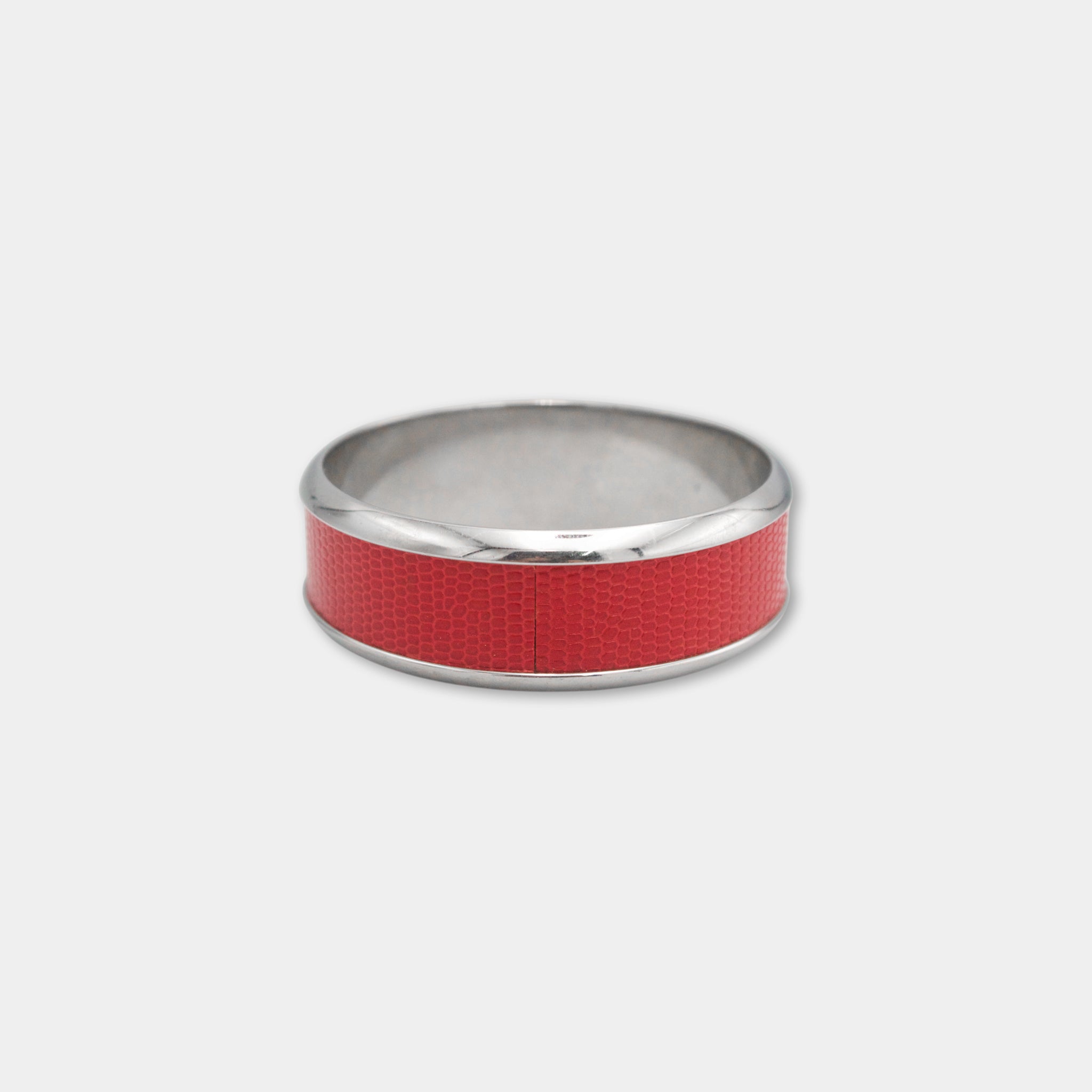 A silver ring with a red band around it.