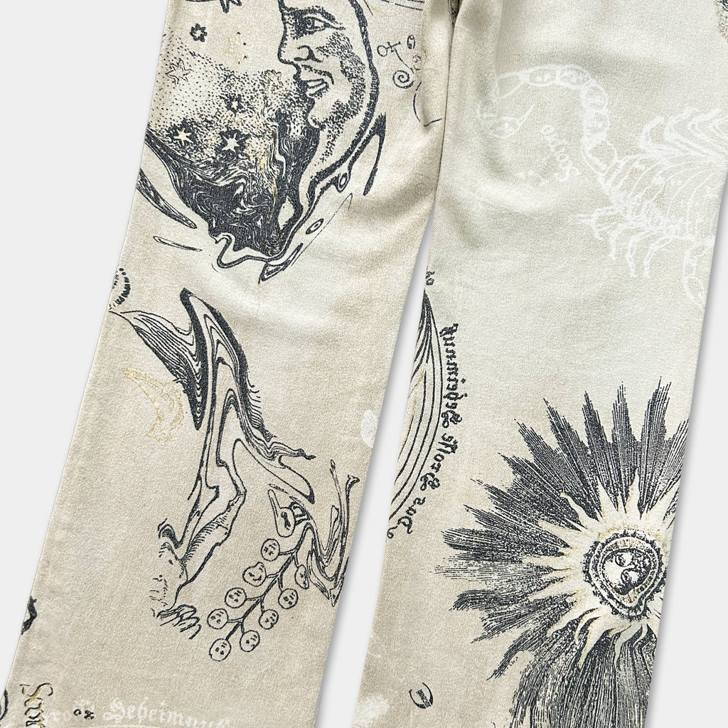 a pair of beige pants with various abstract and artistic designs printed on them, including a face, flowers, and other patterns.