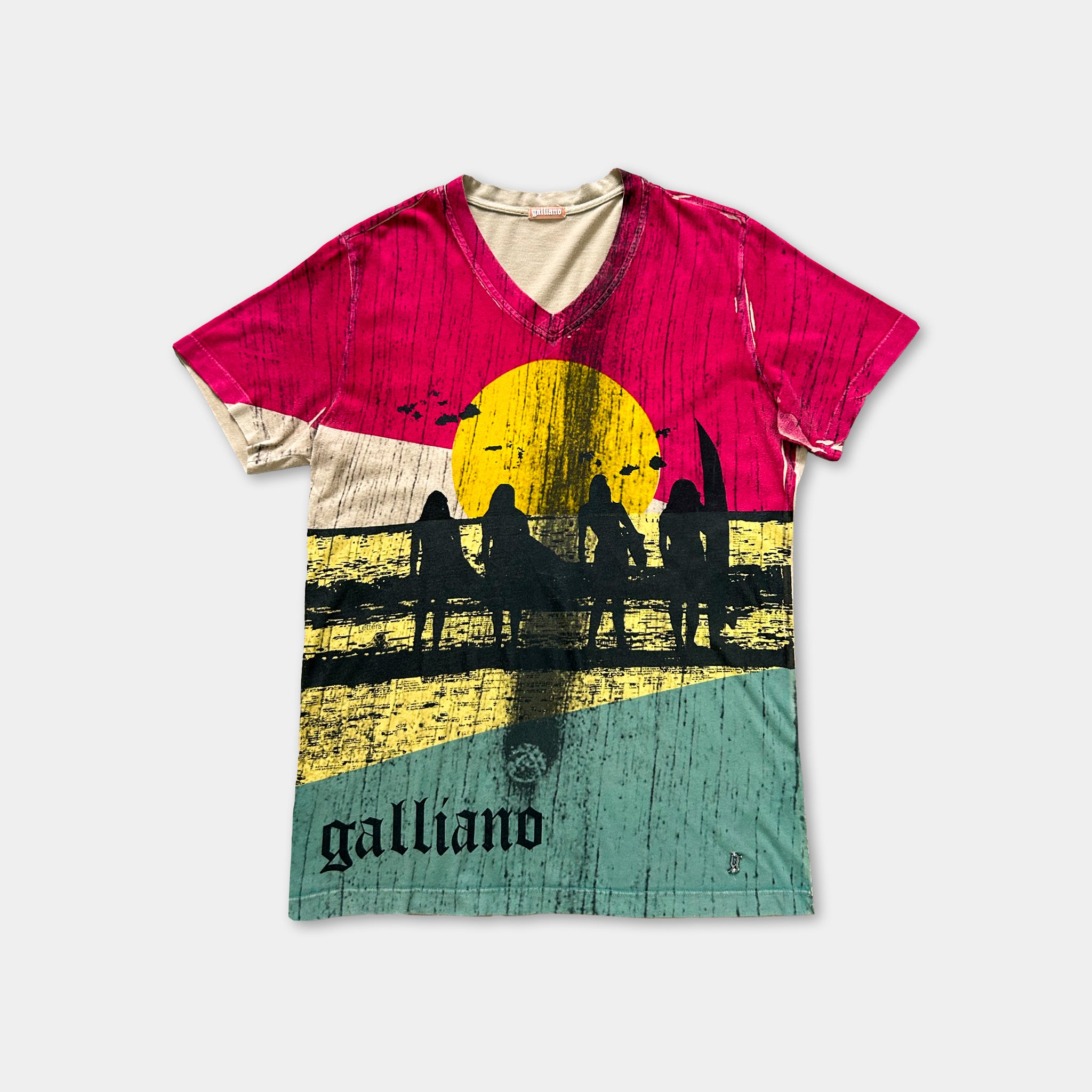 A colorful t-shirt with a graphic design depicting silhouettes of people surfing against a sunset background.