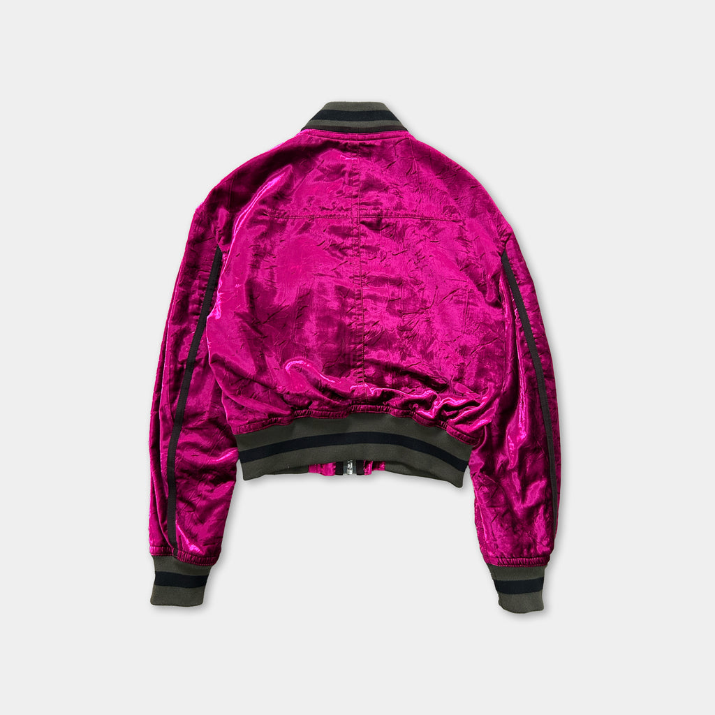 A bright pink velvet jacket with black trim, displayed against a white background.