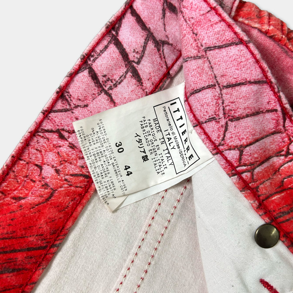 a close-up view of a label attached to a pair of red and white patterned pants.