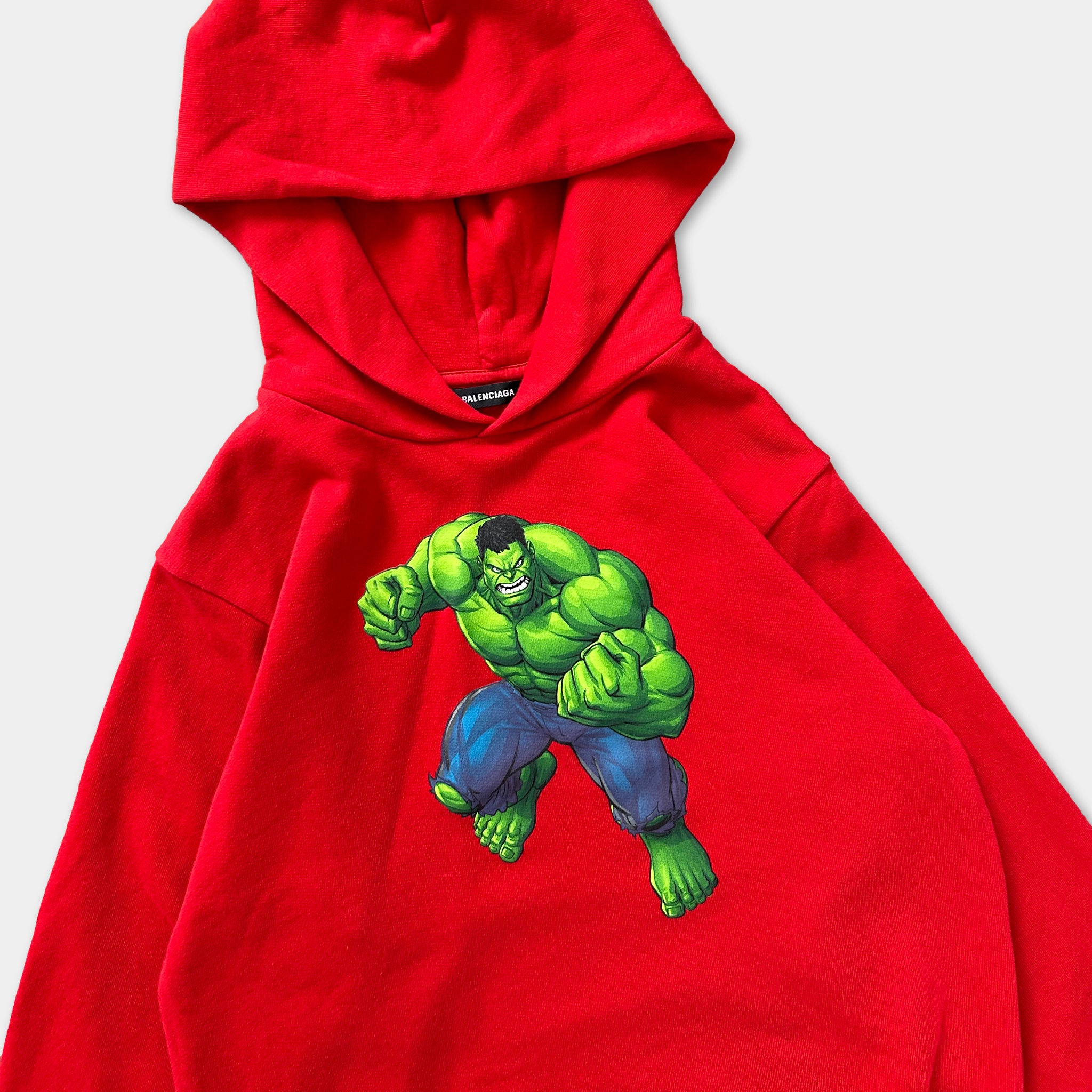 A red hoodie with a graphic of a muscular, green-skinned character on the front.