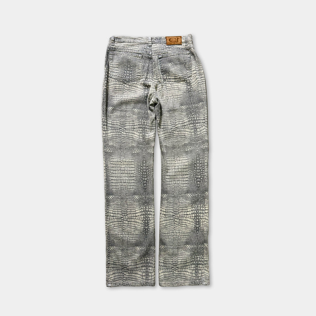 A pair of gray jeans with a crocodile skin pattern.