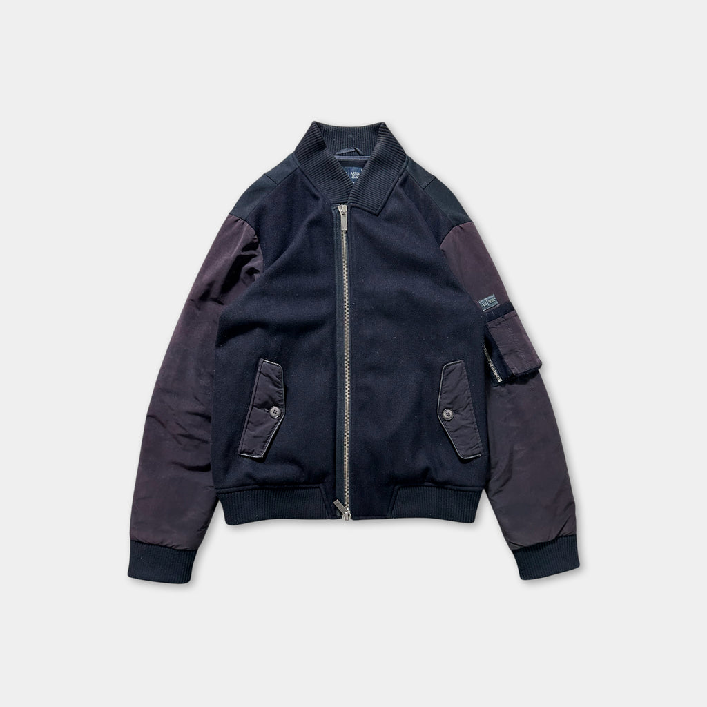 A navy blue jacket with a zipper and pockets, displayed against a white background.