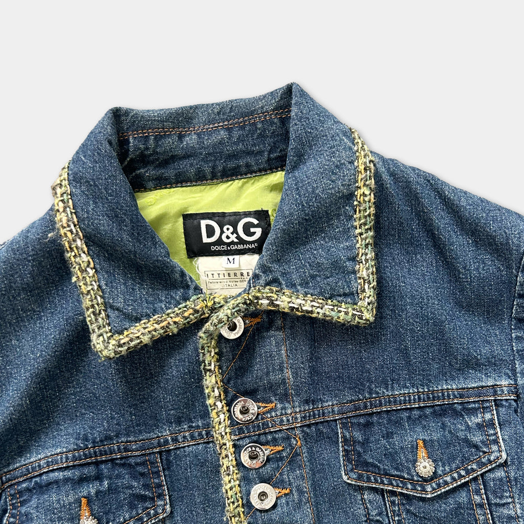 A close-up view of a denim jacket with a yellow trim around the collar and buttons.