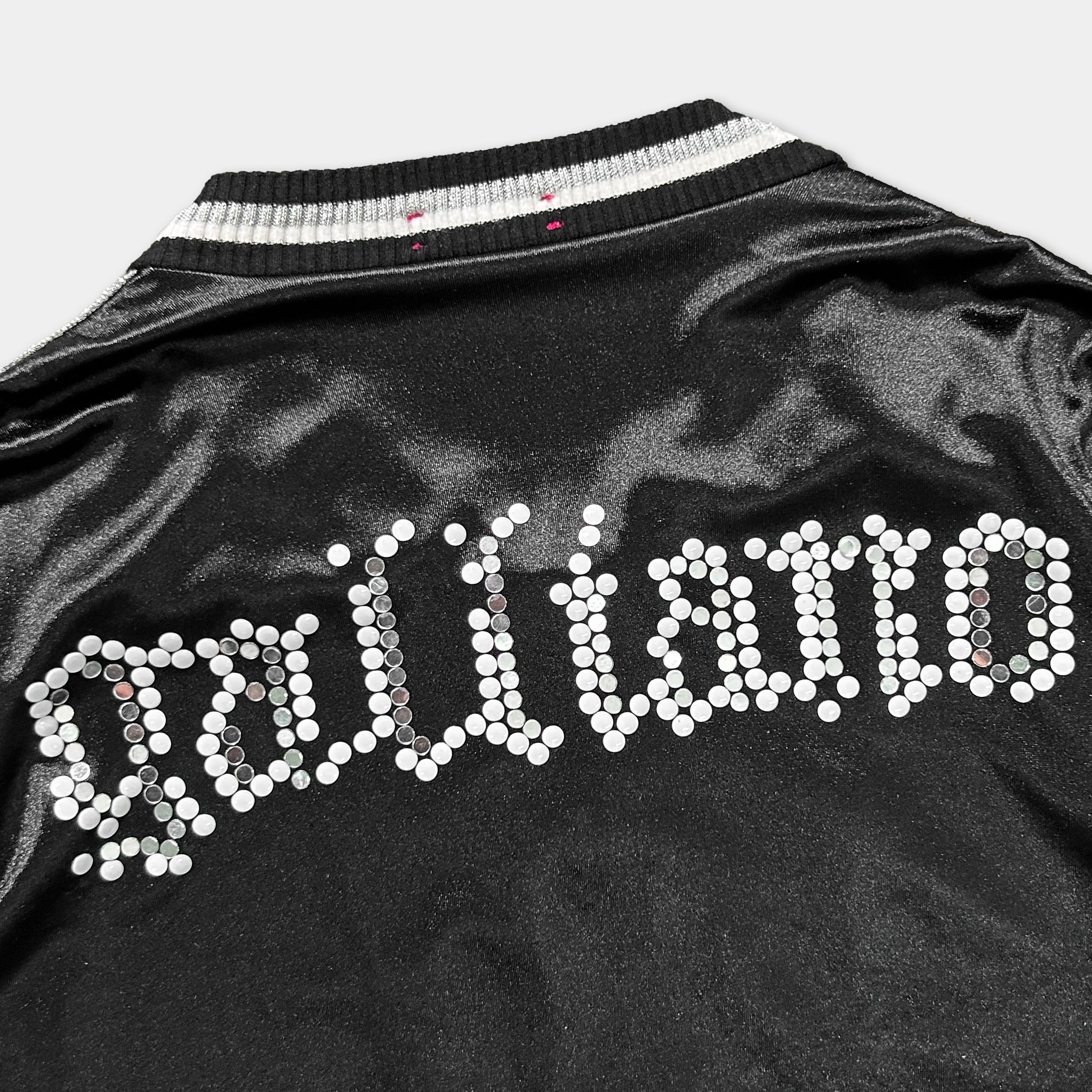 a close-up view of a black jacket with white dots arranged in a decorative pattern, covering the back of the jacket.