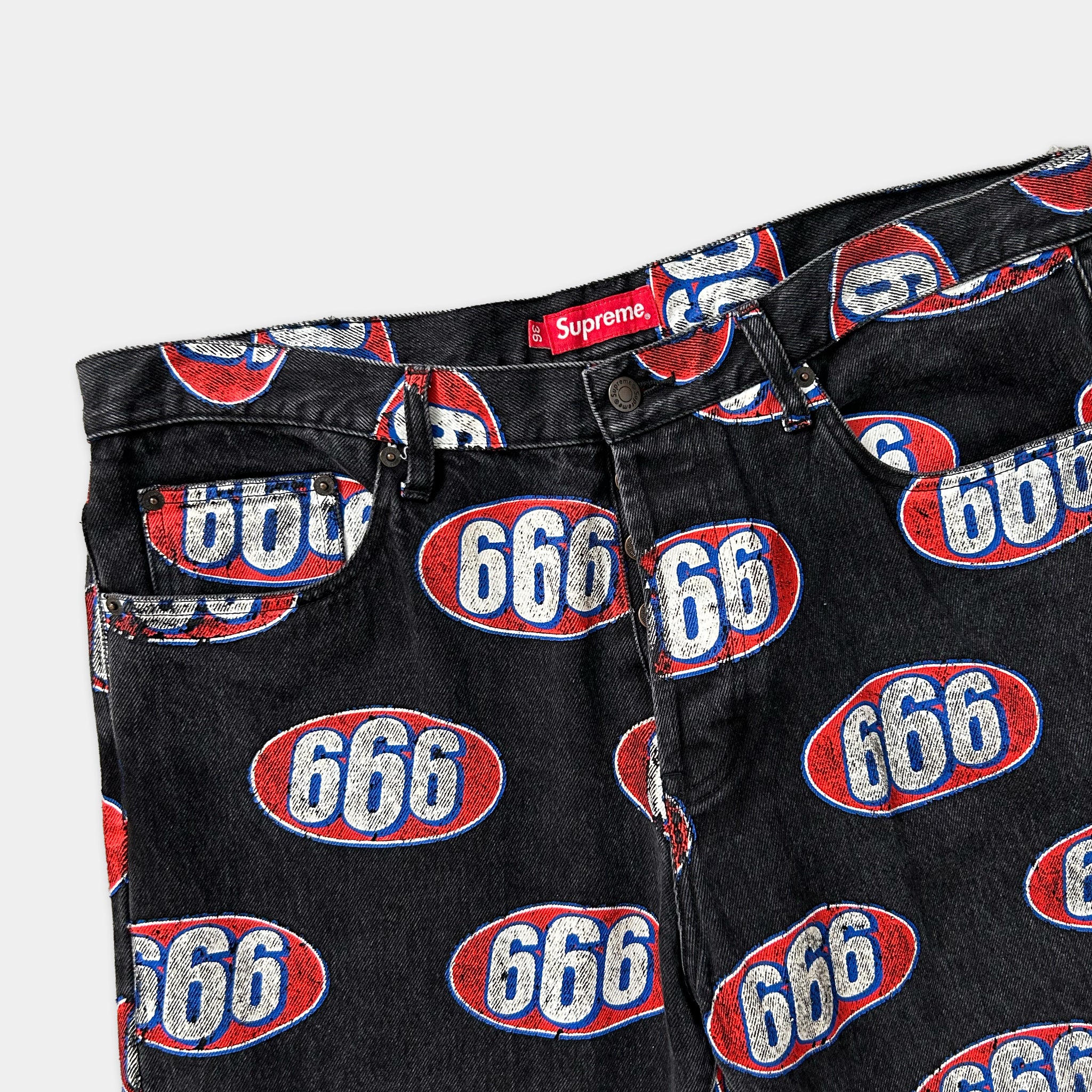 A pair of black jeans with a repeating pattern of the number 666 in red, white, and blue.