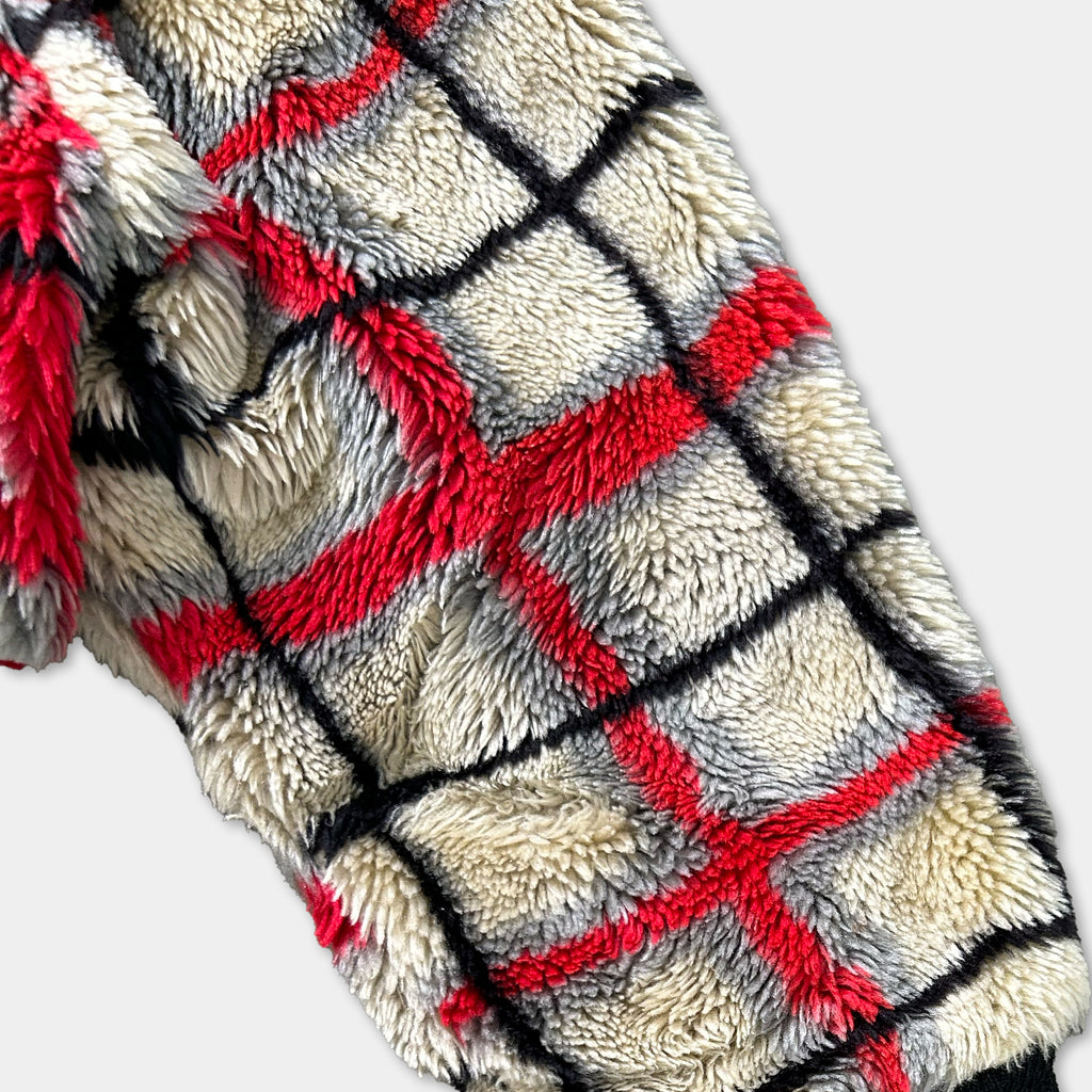 a close-up view of a soft, furry fabric with a distinctive red and black checkered pattern.