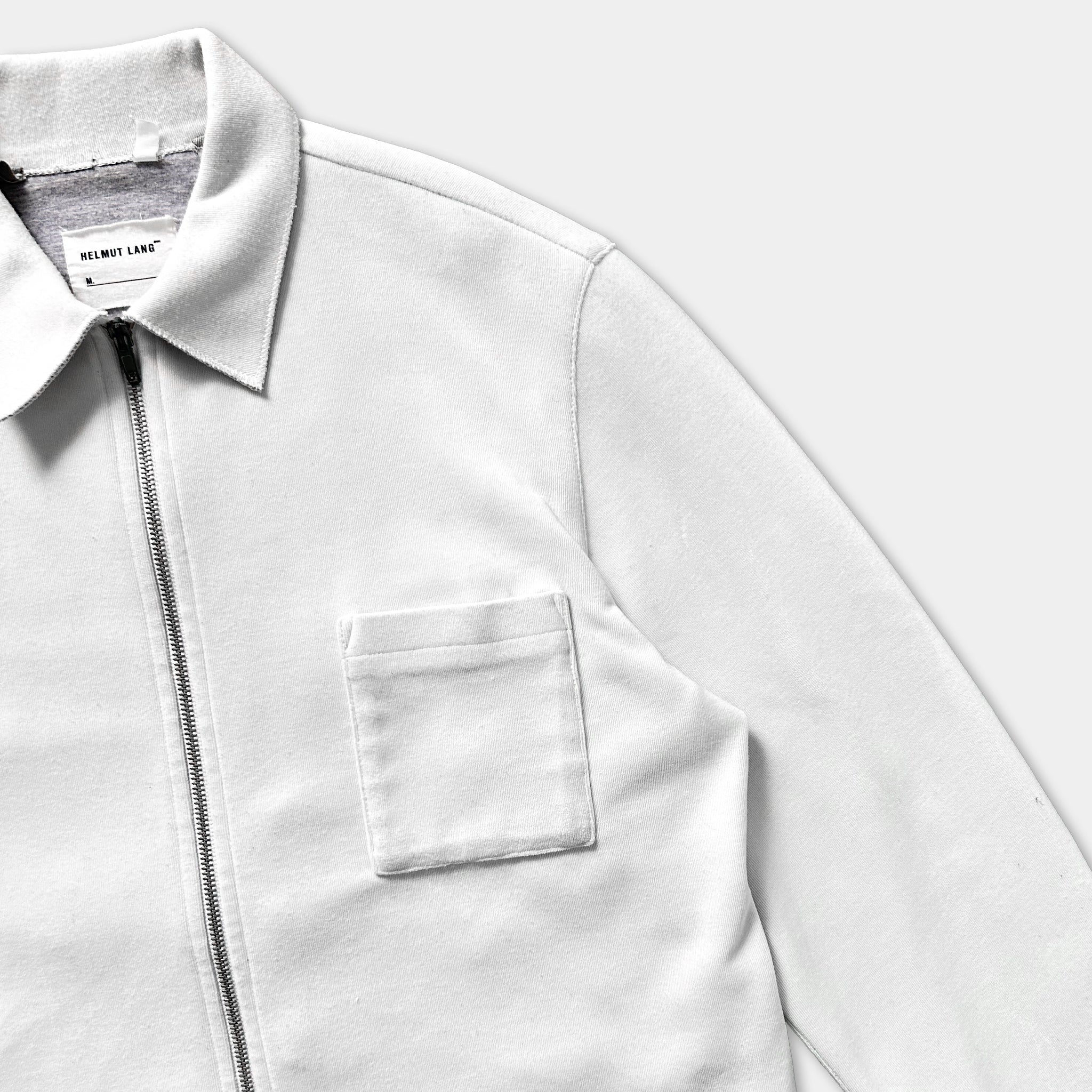 A white zip-up jacket with a collar and a pocket.
