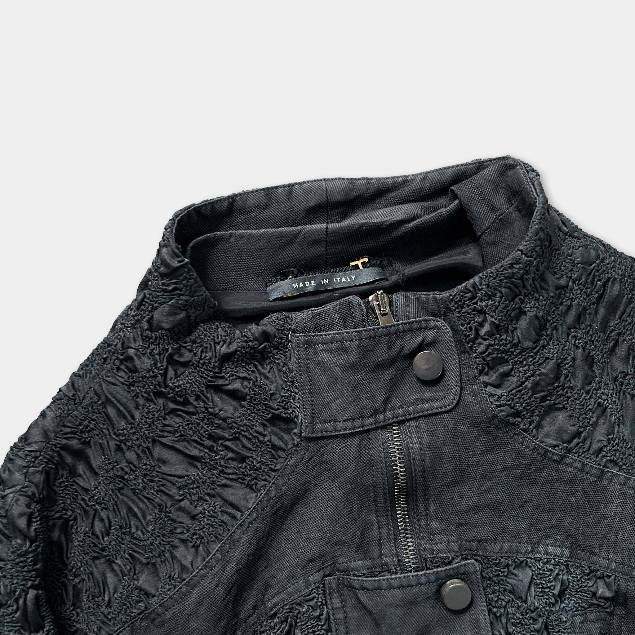 A close-up view of a black jacket with a label that reads "MADE IN ITALY".