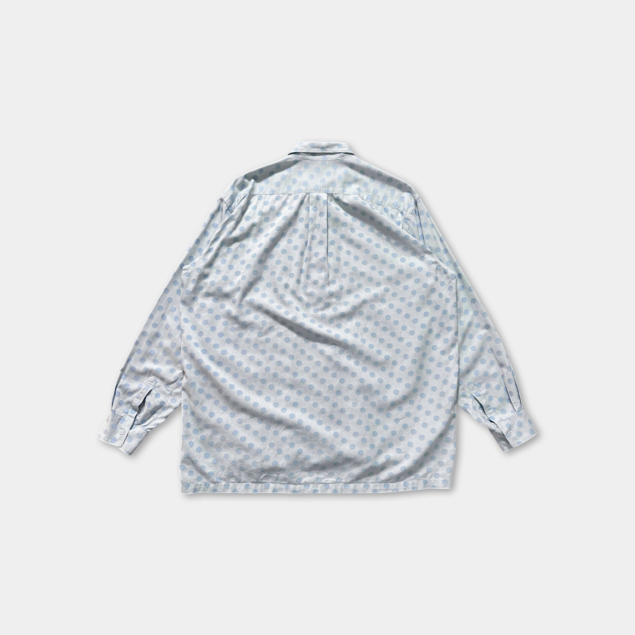 a light blue shirt with a pattern of small circles, laid out flat against a white background.