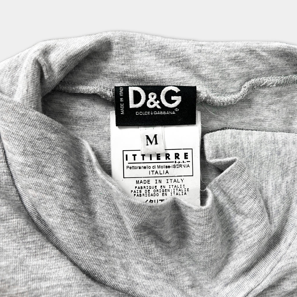 A close-up of a gray t-shirt with a D&G logo and a label indicating the brand and country of production.