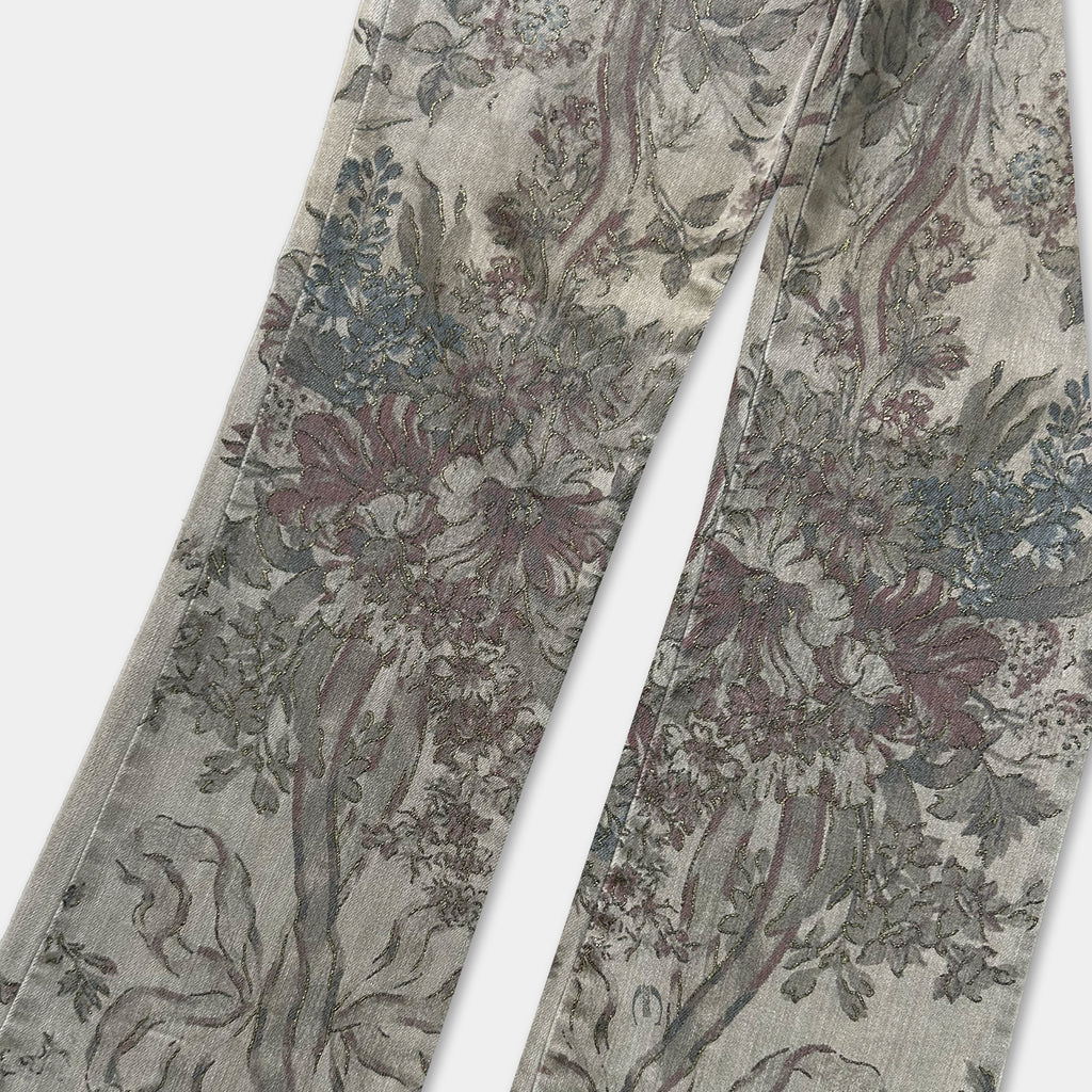 a pair of floral patterned jeans, featuring a detailed and intricate design with various shades of green, red, and gray.