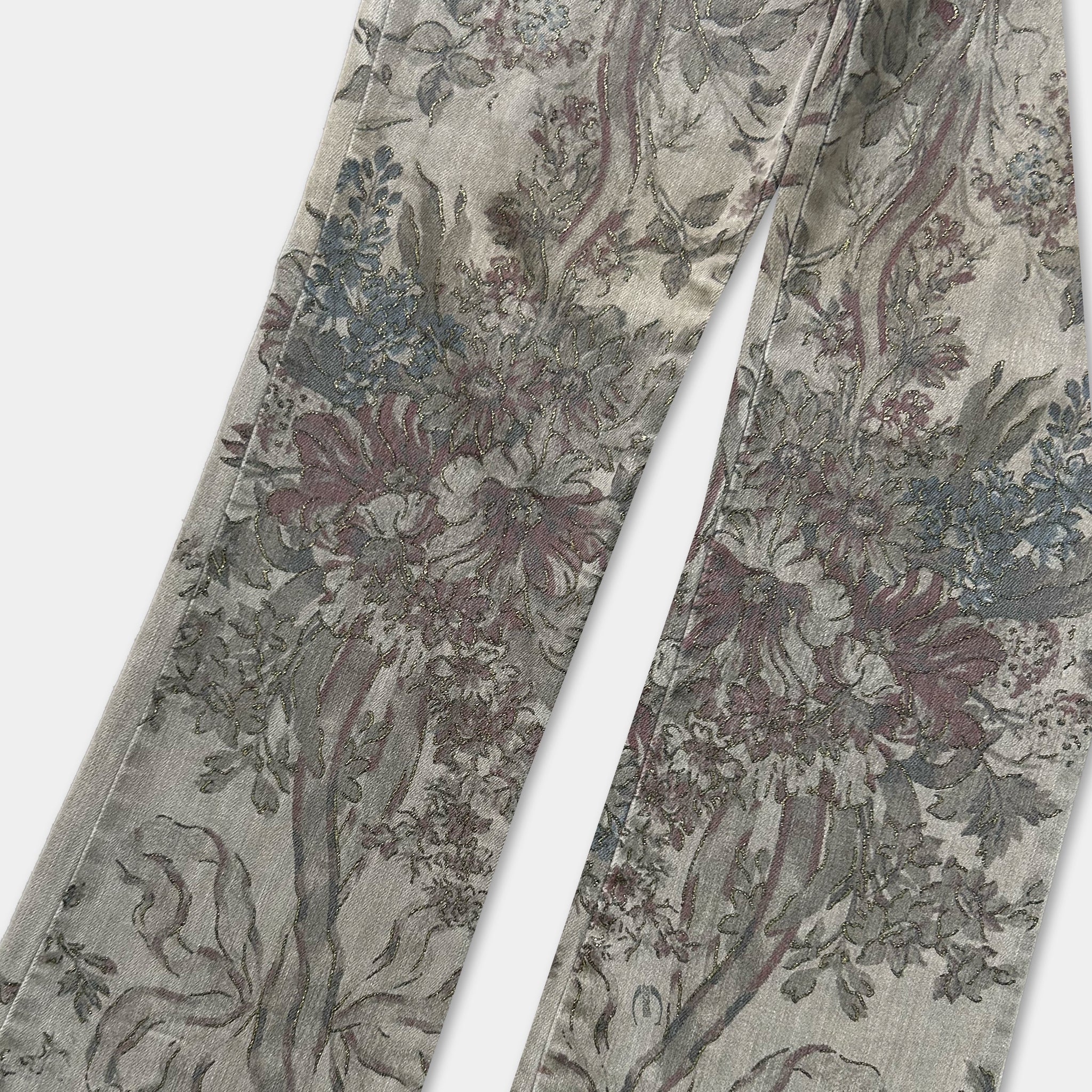 a pair of floral patterned jeans, featuring a detailed and intricate design with various shades of green, red, and gray.