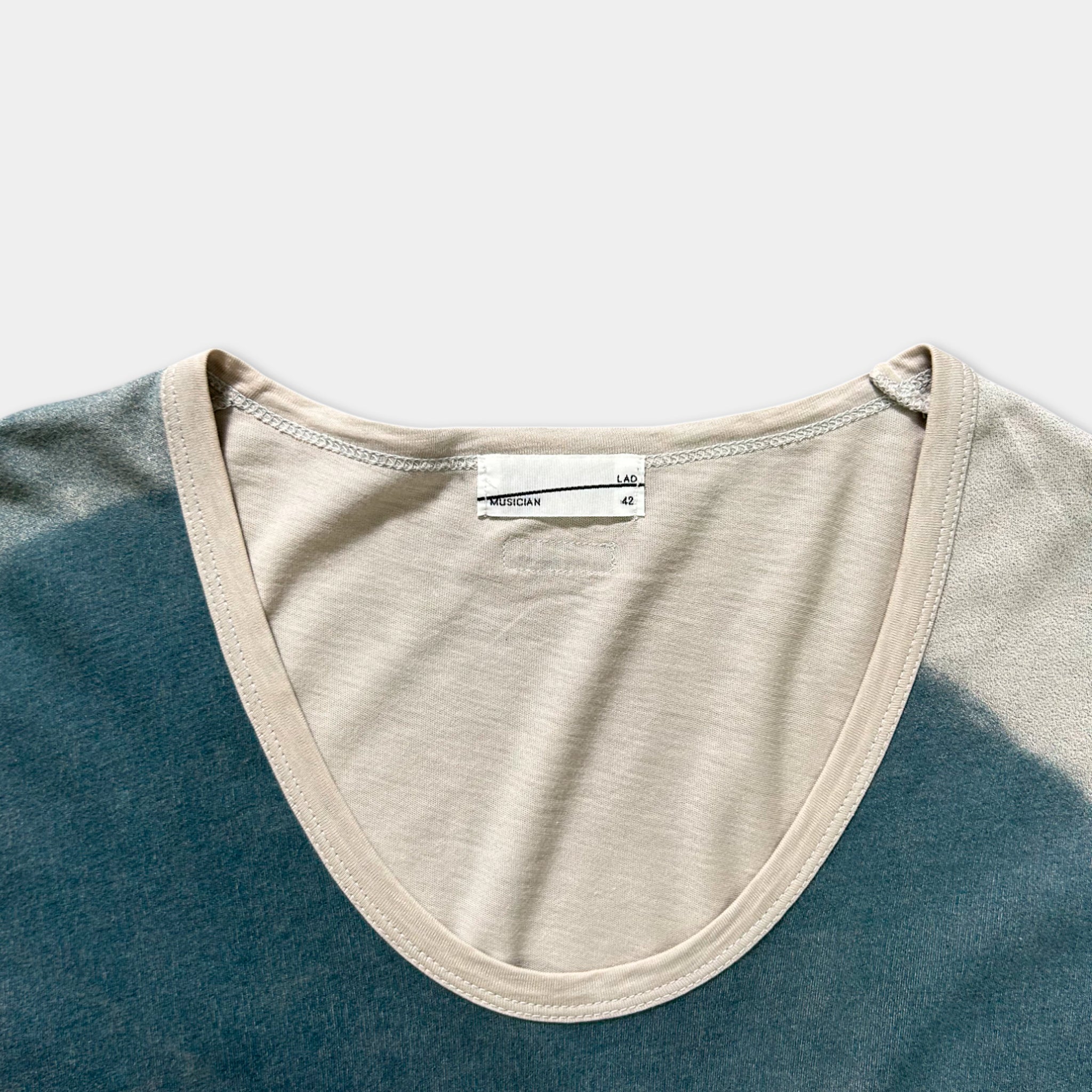 a close-up view of a beige and blue shirt with a label on the collar.