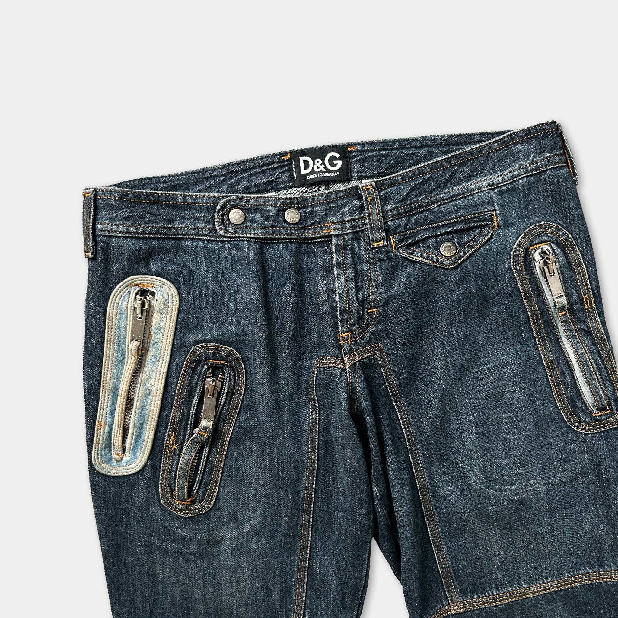 A pair of blue denim jeans with multiple zippers and pockets, including a zipper pull and a zipper pull with a zipper pull.