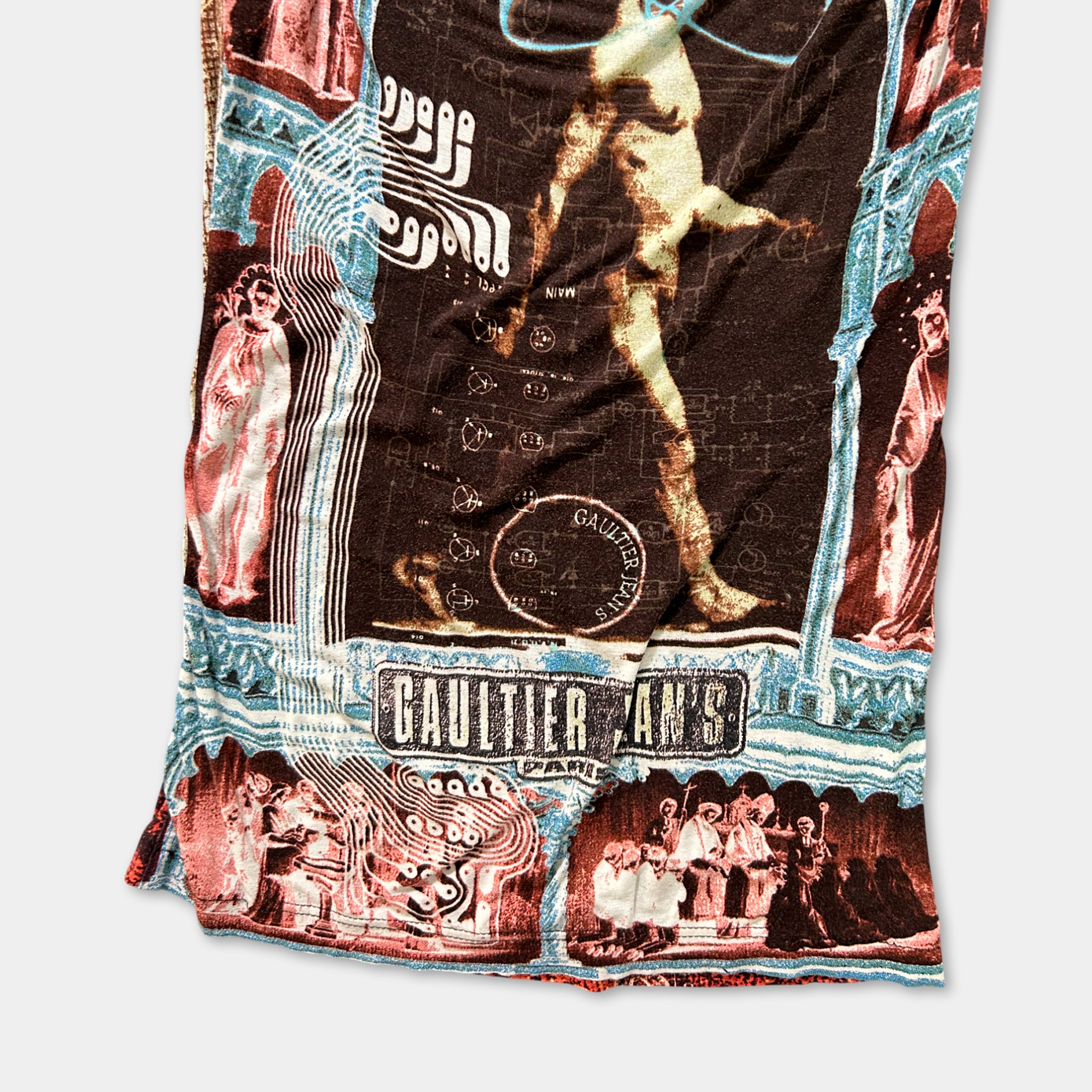 The image is a collage of various images, including a large figure, a group of people, and other abstract and symbolic elements. The collage is framed by a border, and the text "Gaultier's" is visible, suggesting it may be related to the fashion brand or theme of the collage.