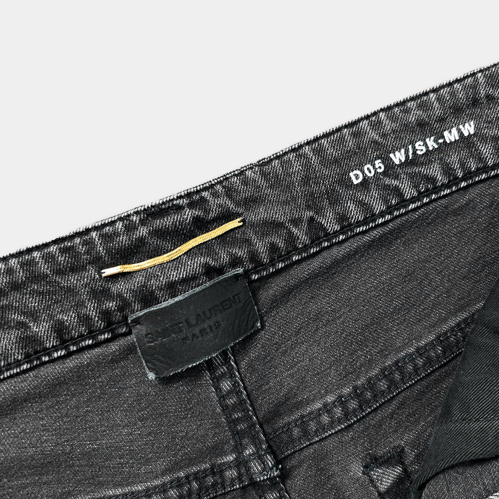 a close-up view of a pair of black jeans with a label attached to the waistband.