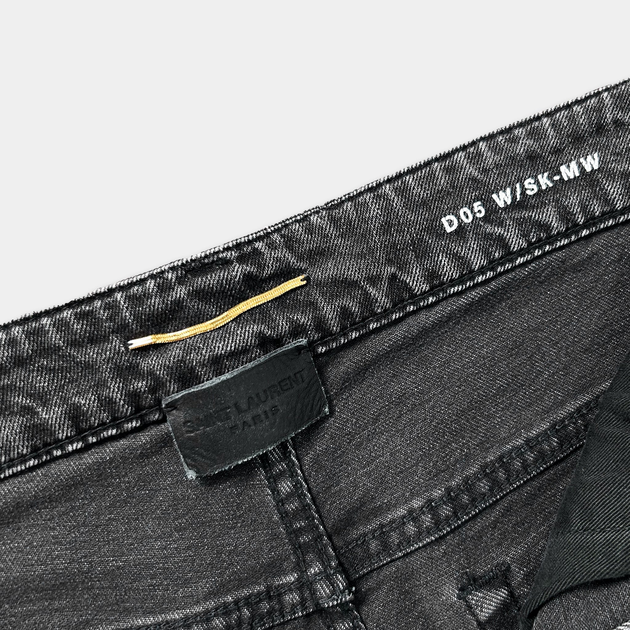 a close-up view of a pair of black jeans with a label attached to the waistband.
