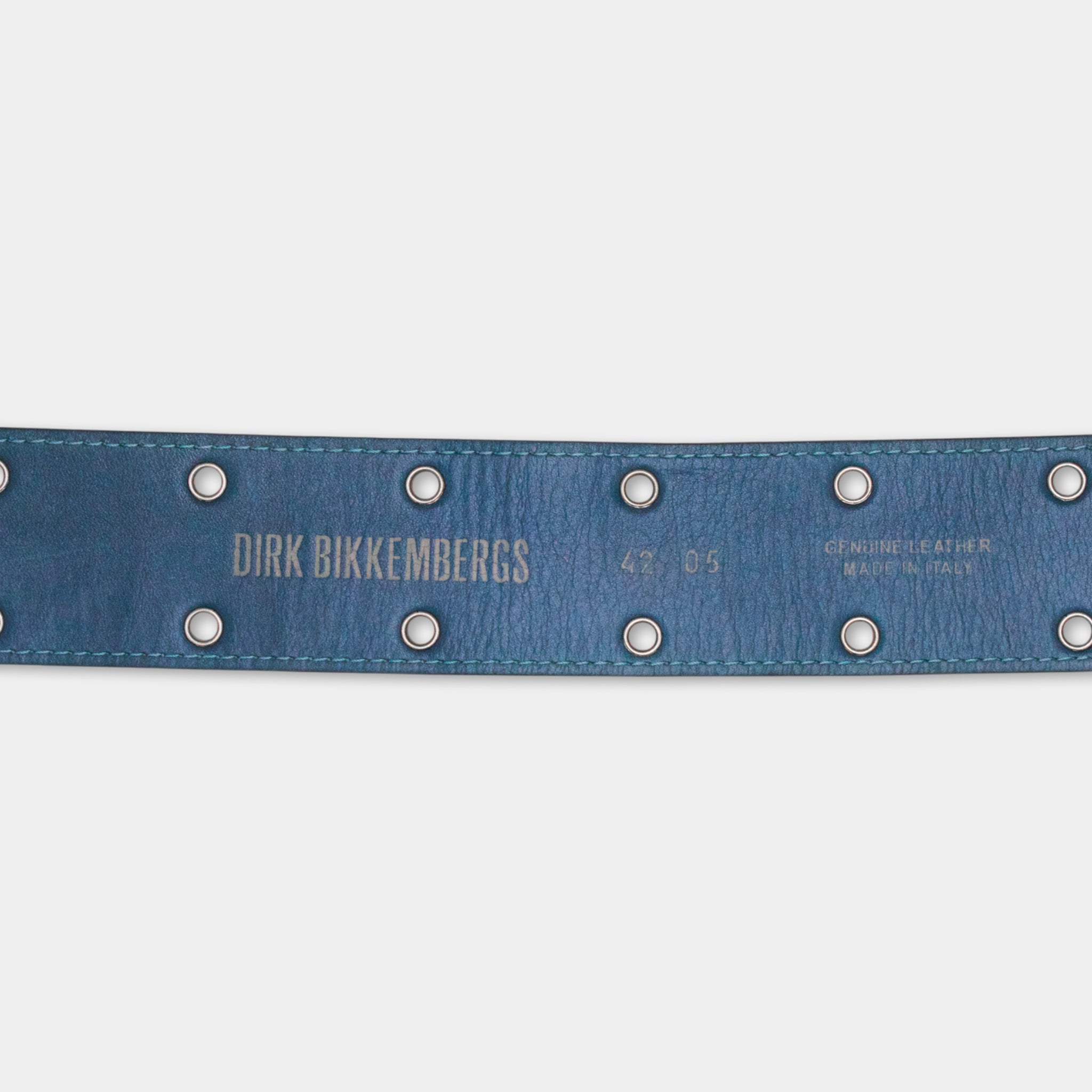A close-up view of a blue leather belt with metal studs, featuring the name 'Dirk Bikkebergs' and the number '42.05' printed on it.