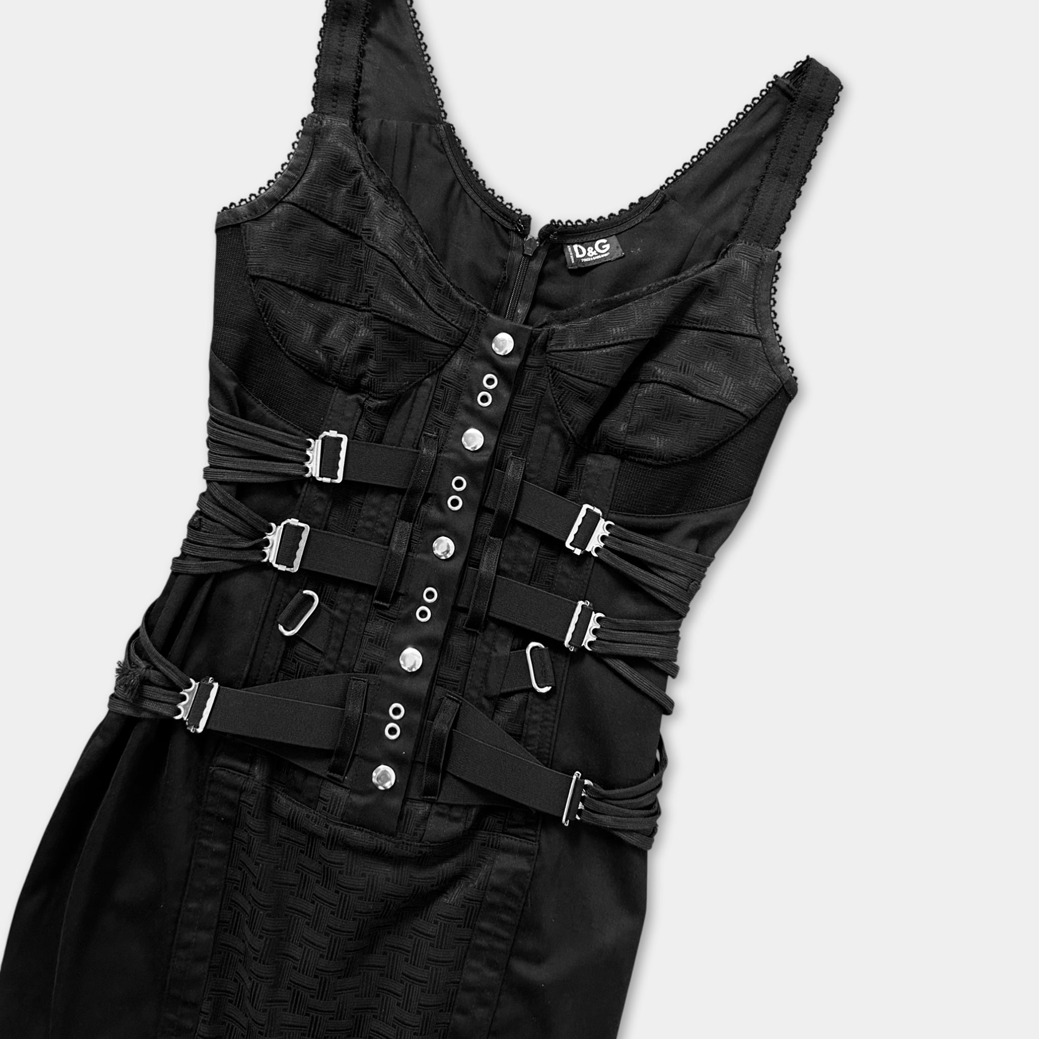 A black dress with multiple straps and buckles, likely designed for a gothic or punk-inspired style.