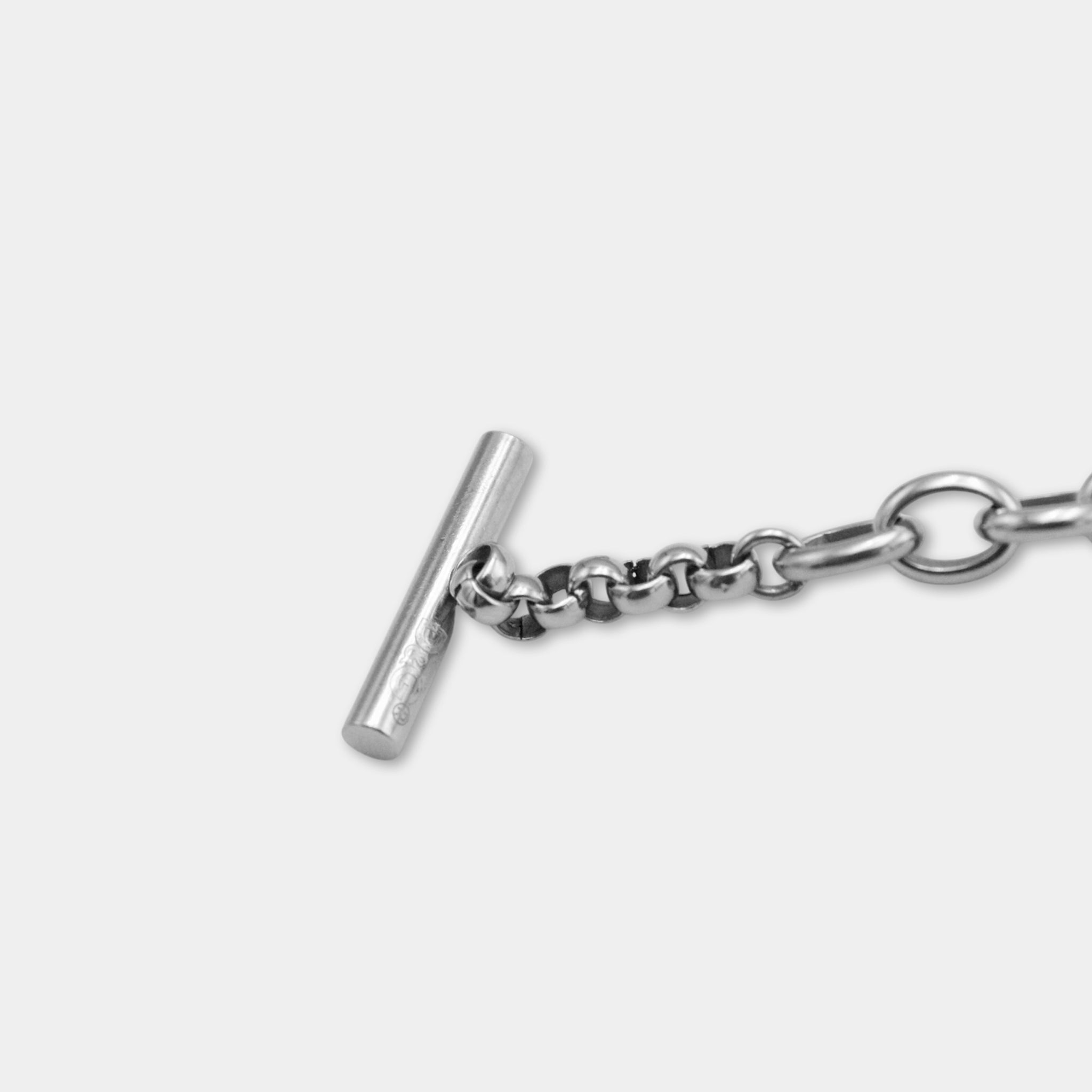 A silver chain with a small metal bar attached to it.
