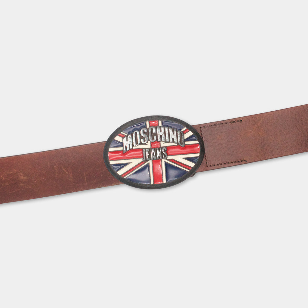 A brown leather belt with a round metal buckle featuring the Moschino Jeans logo.