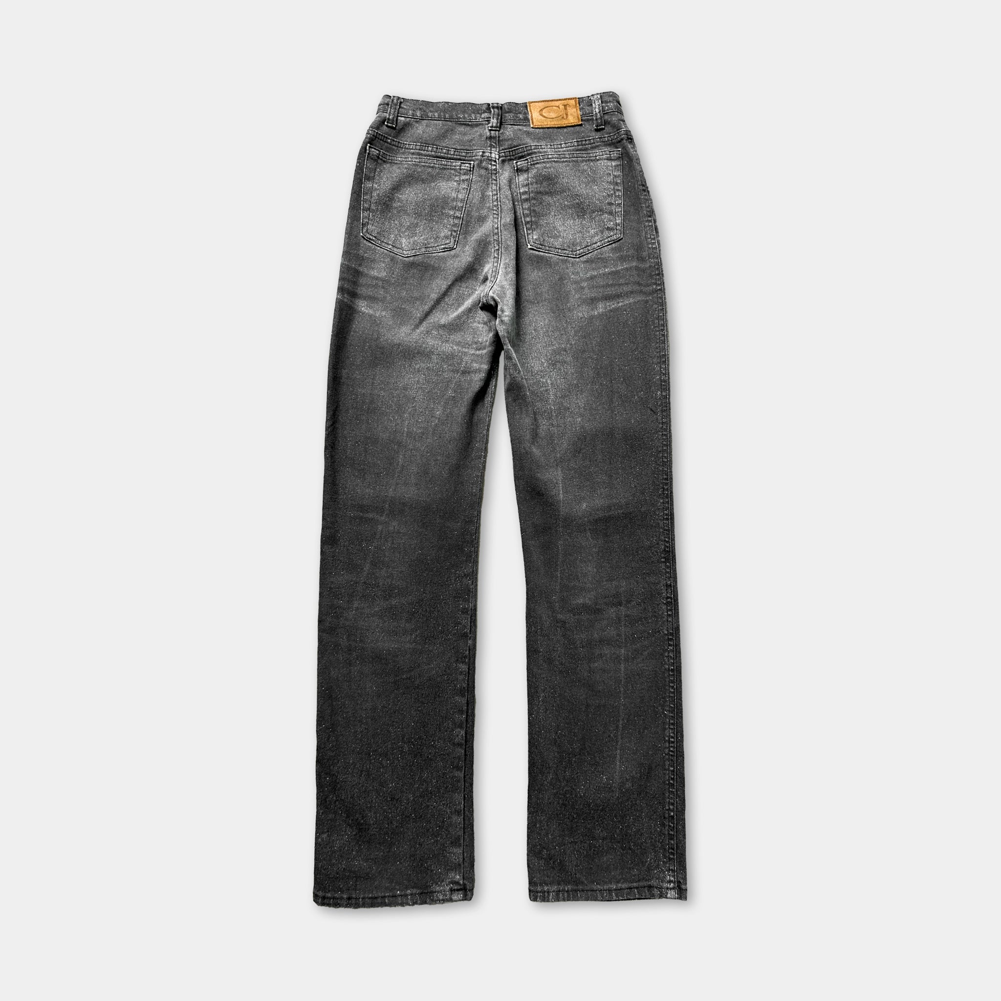 A pair of black, distressed jeans with a label on the back pocket.