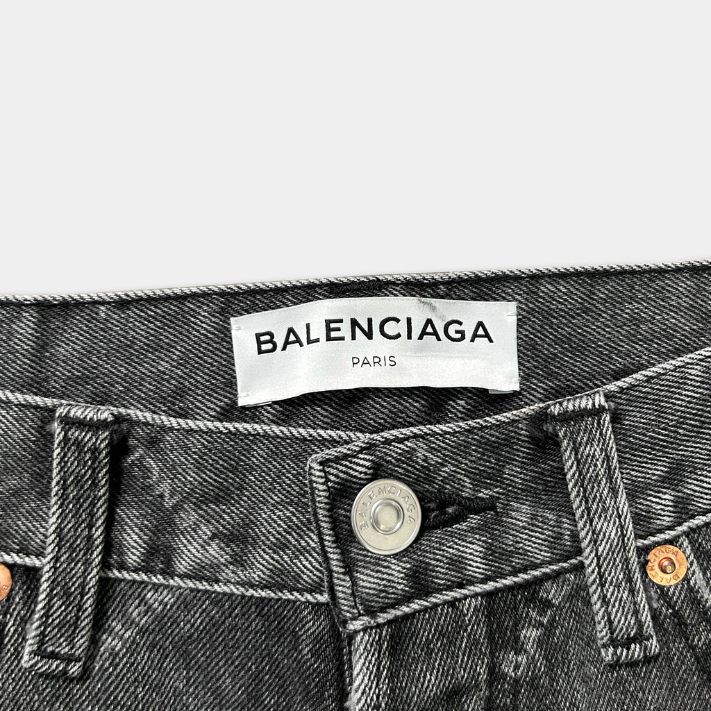A close-up view of a pair of black denim jeans with a label that reads "BALENCIA PARIS".
