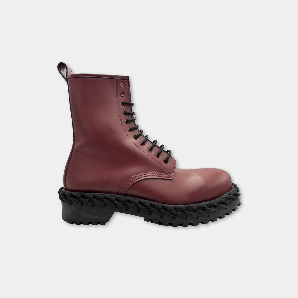A red leather boot with a thick rubber sole and black laces.