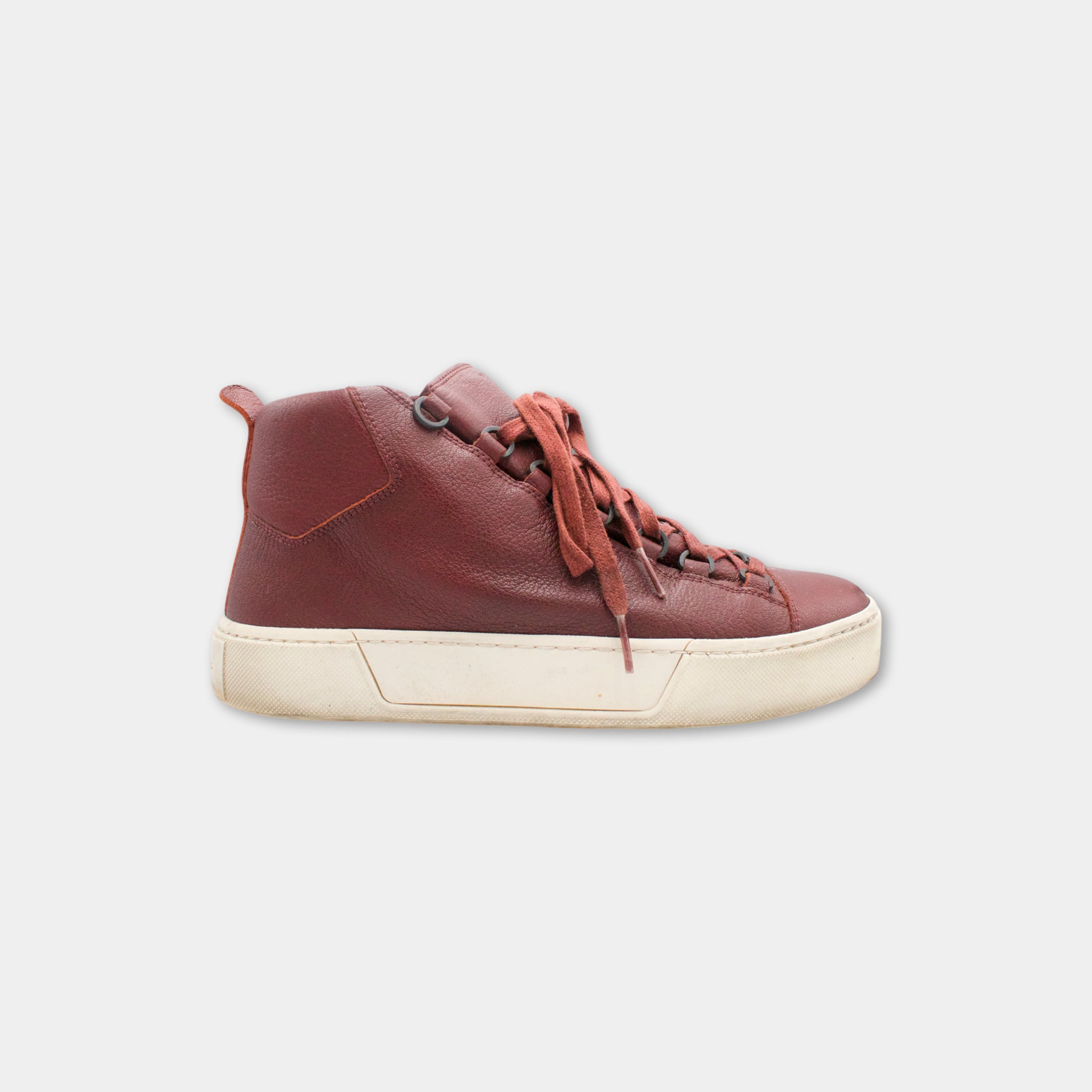 A single red high-top sneaker with a white sole, shown against a plain white background.